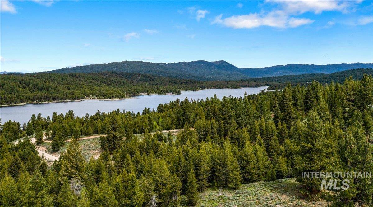 View of mountain backdrop featuring a forest and a large body of water