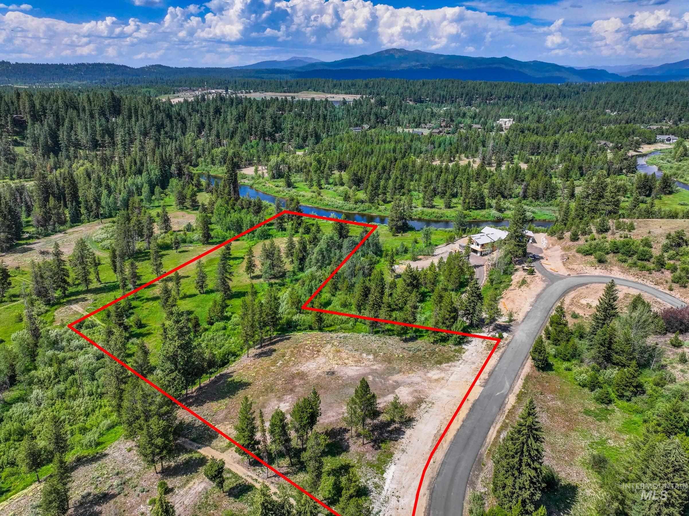 Aerial view of property and surrounding area with property boundaries highlighted and a water and mountain view