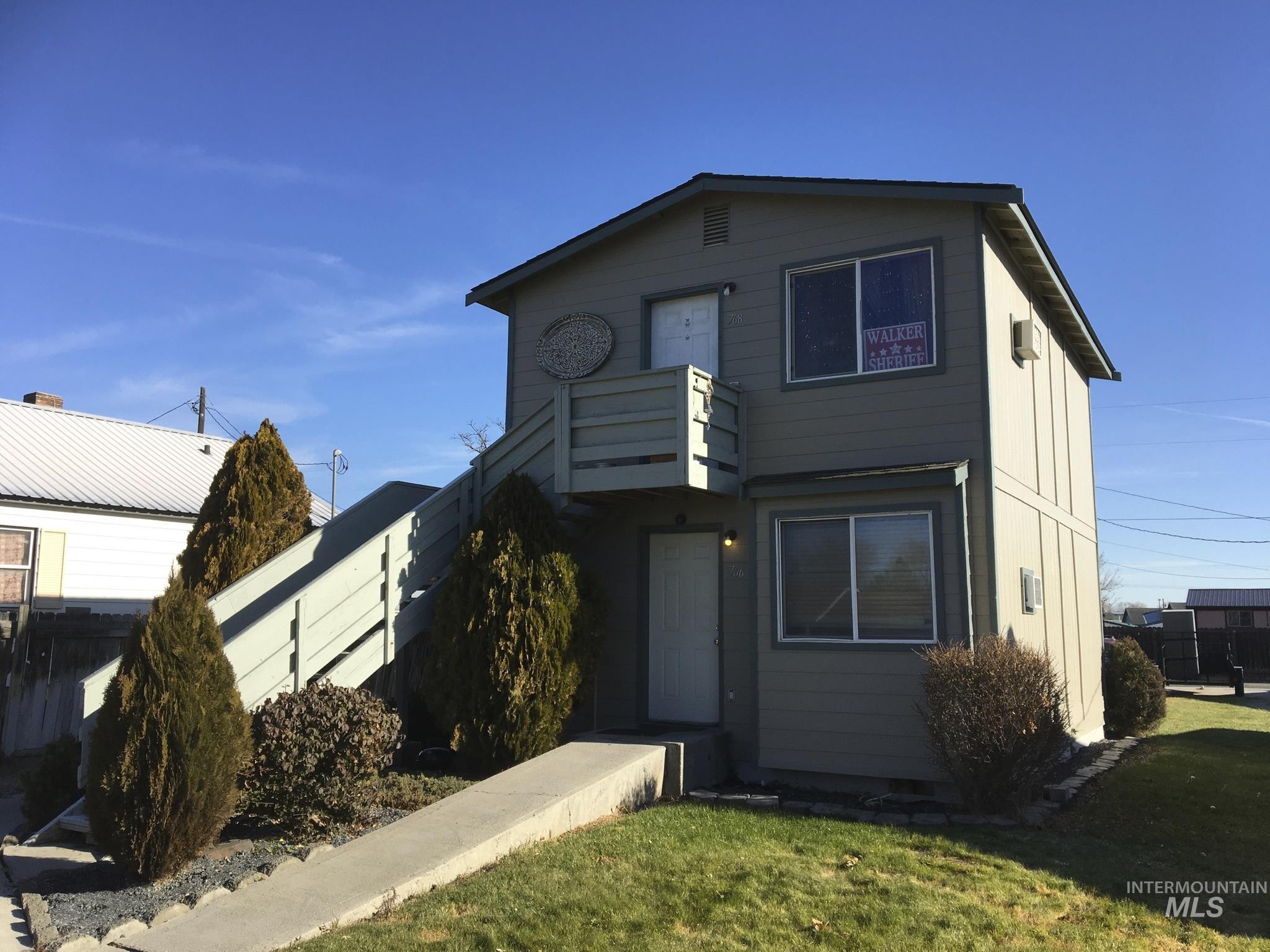 View of front of house with a front lawn and a balcony