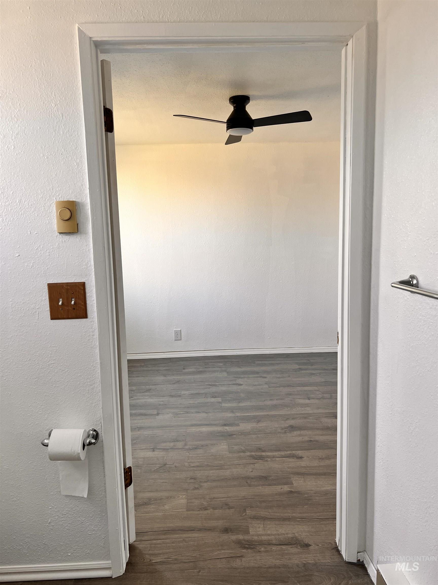 Hall featuring dark wood finished floors and baseboards