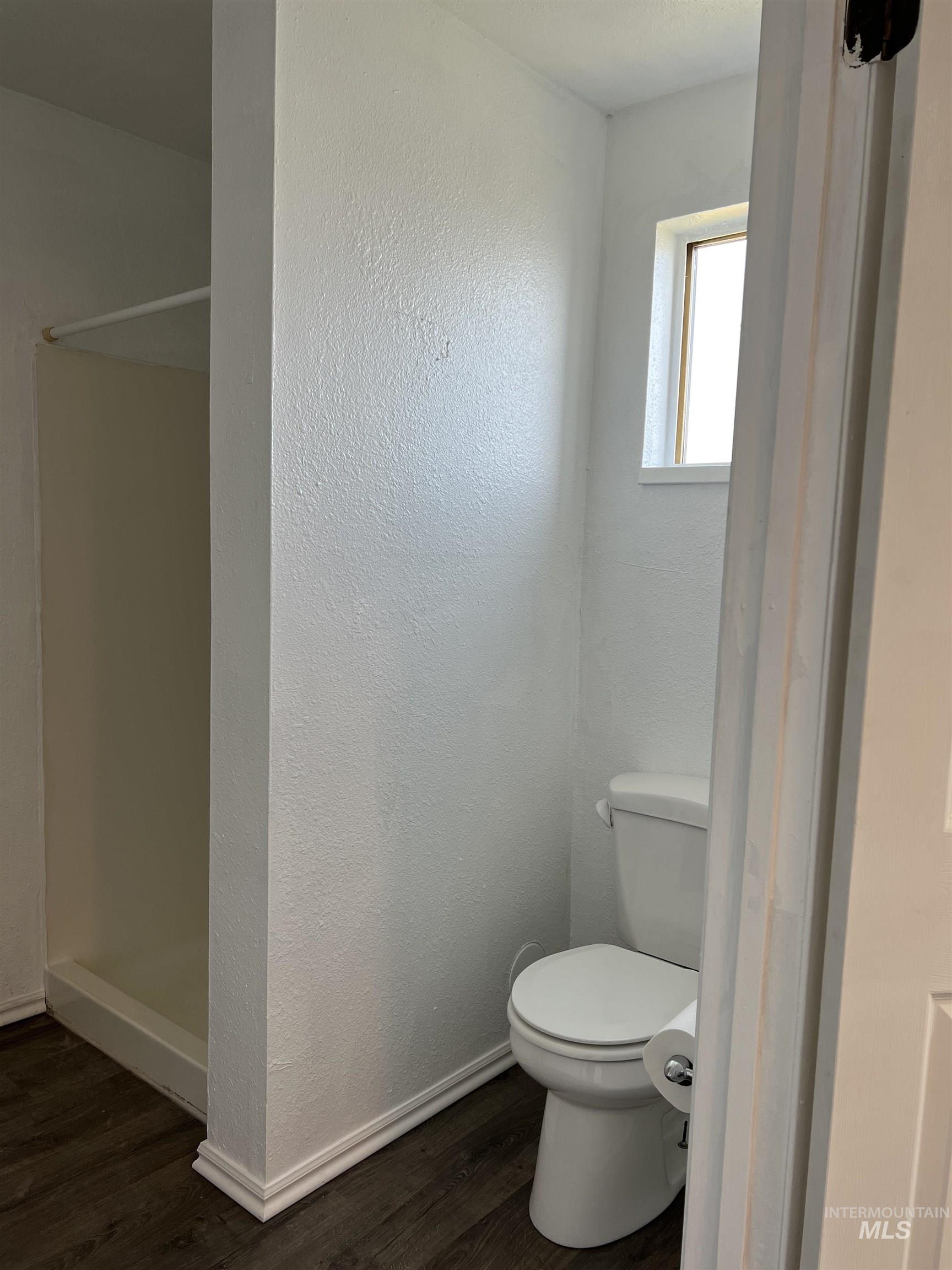 Full bath with a shower stall and wood finished floors