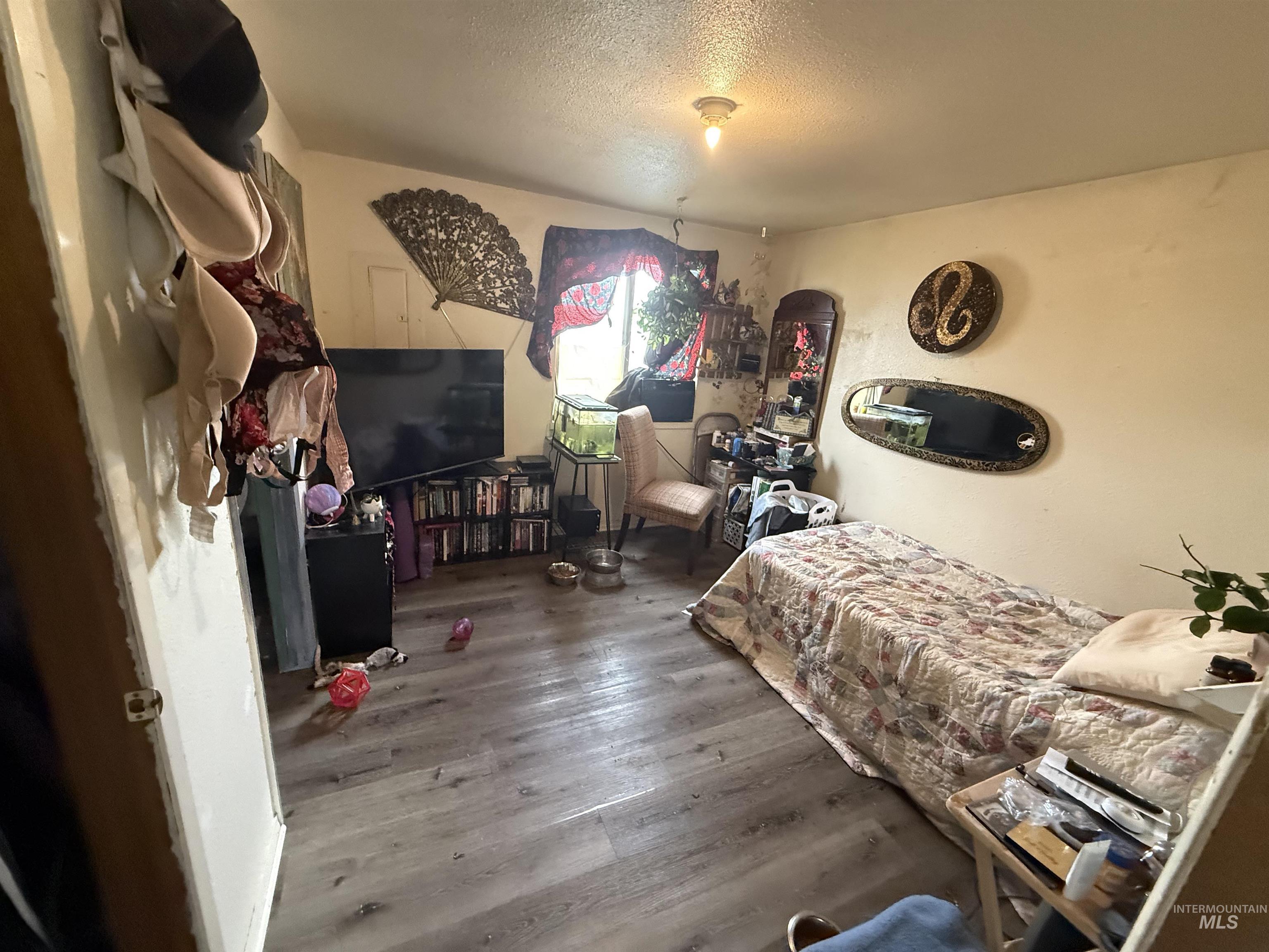 Bedroom with wood finished floors and a textured ceiling