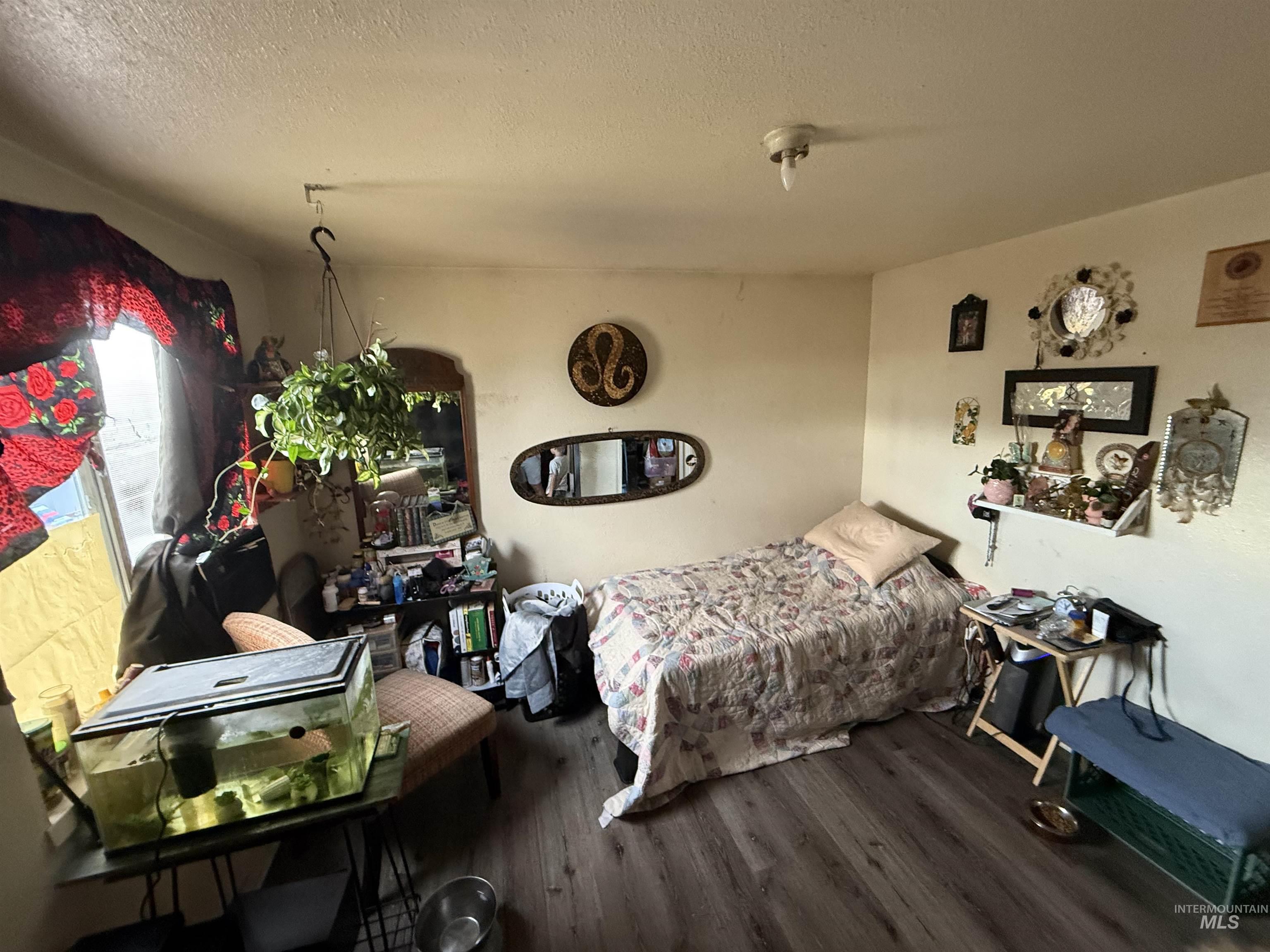 Bedroom featuring wood finished floors and a textured ceiling