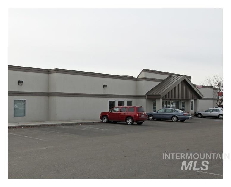 View of building exterior featuring uncovered parking