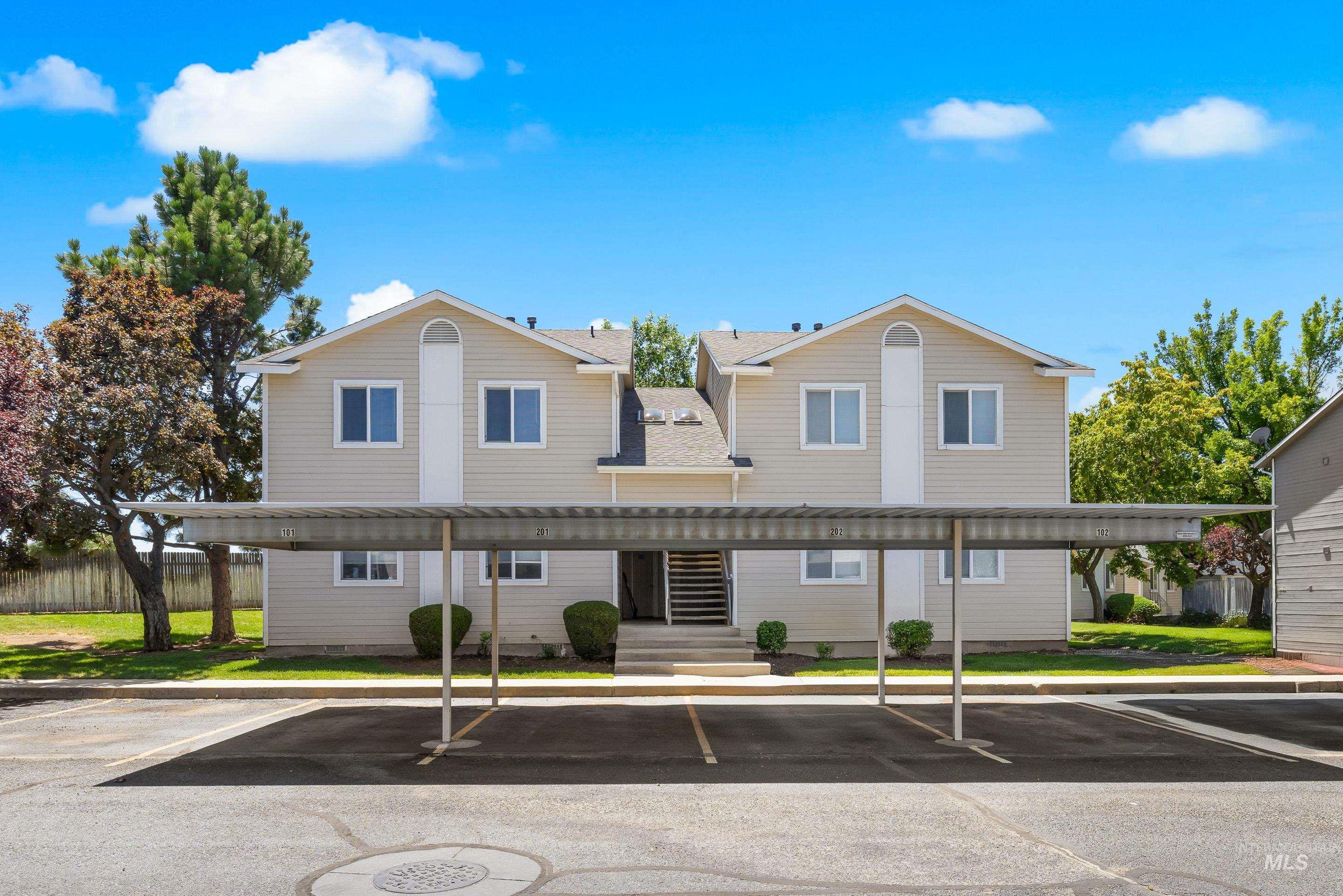 View of front of home with covered parking and a shingled roof