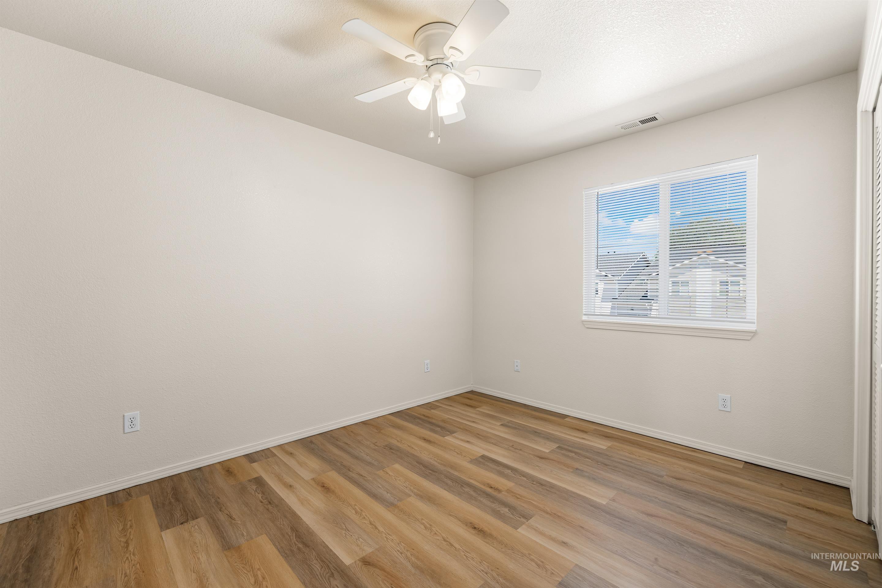 Unfurnished room with light wood-style flooring and a ceiling fan