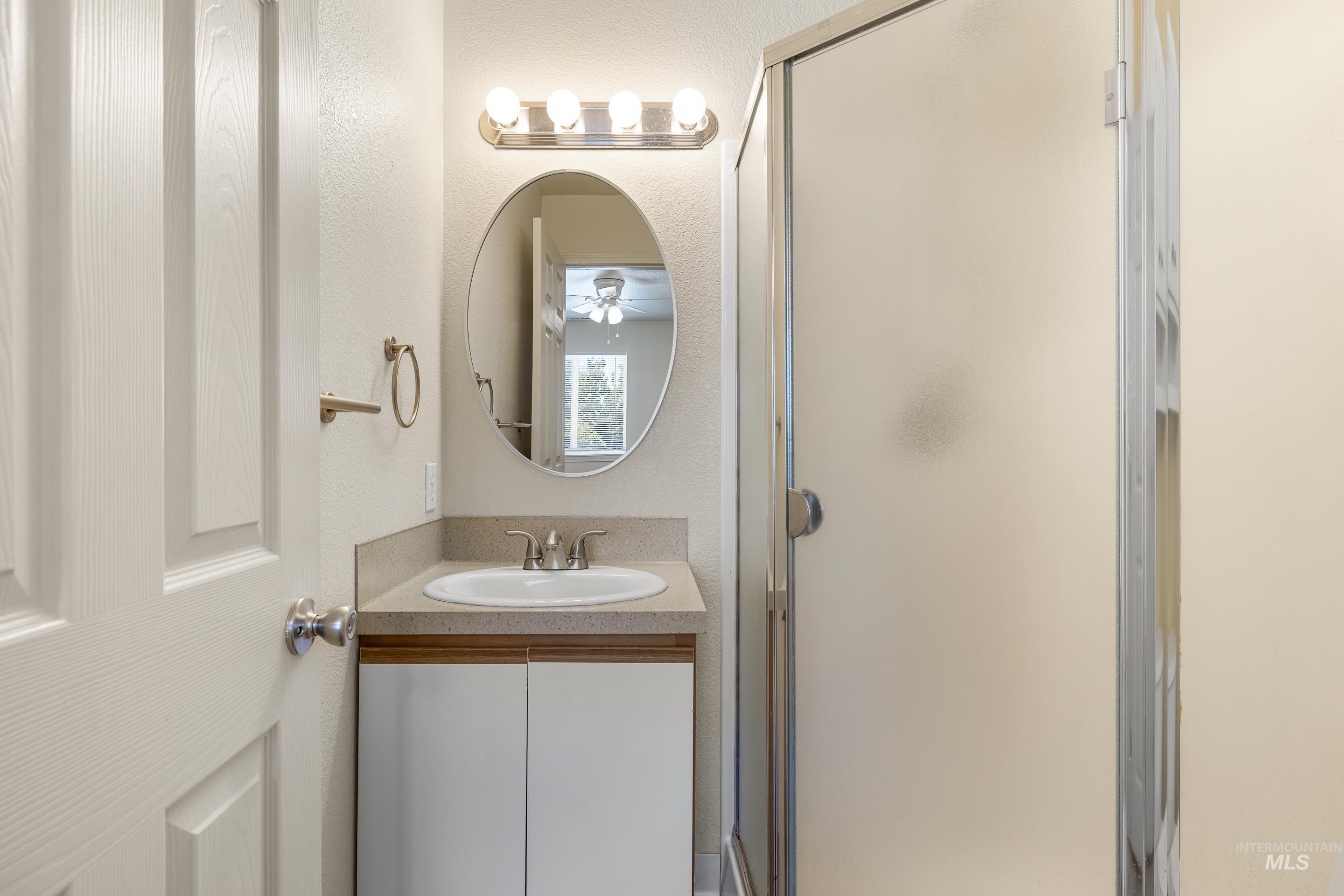 Bathroom with a stall shower and vanity