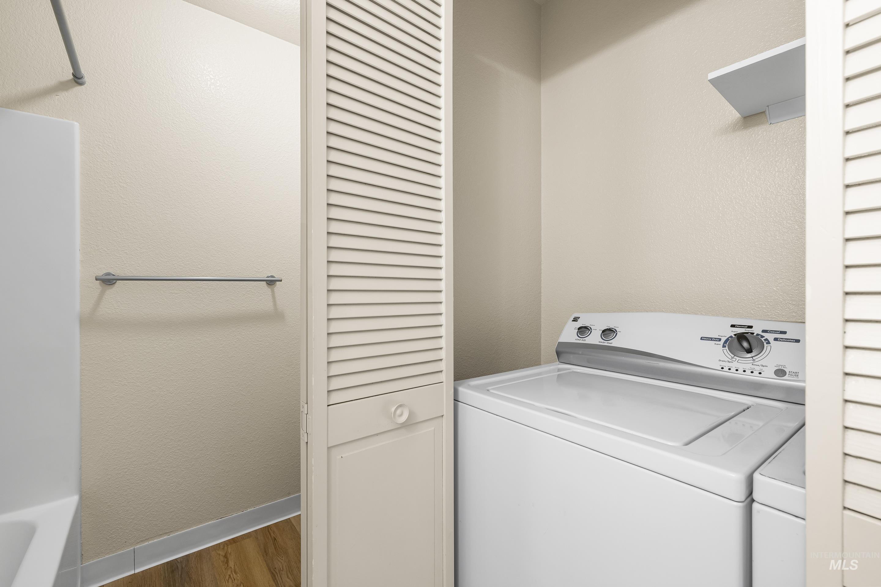 Laundry room featuring wood finished floors and washer and clothes dryer
