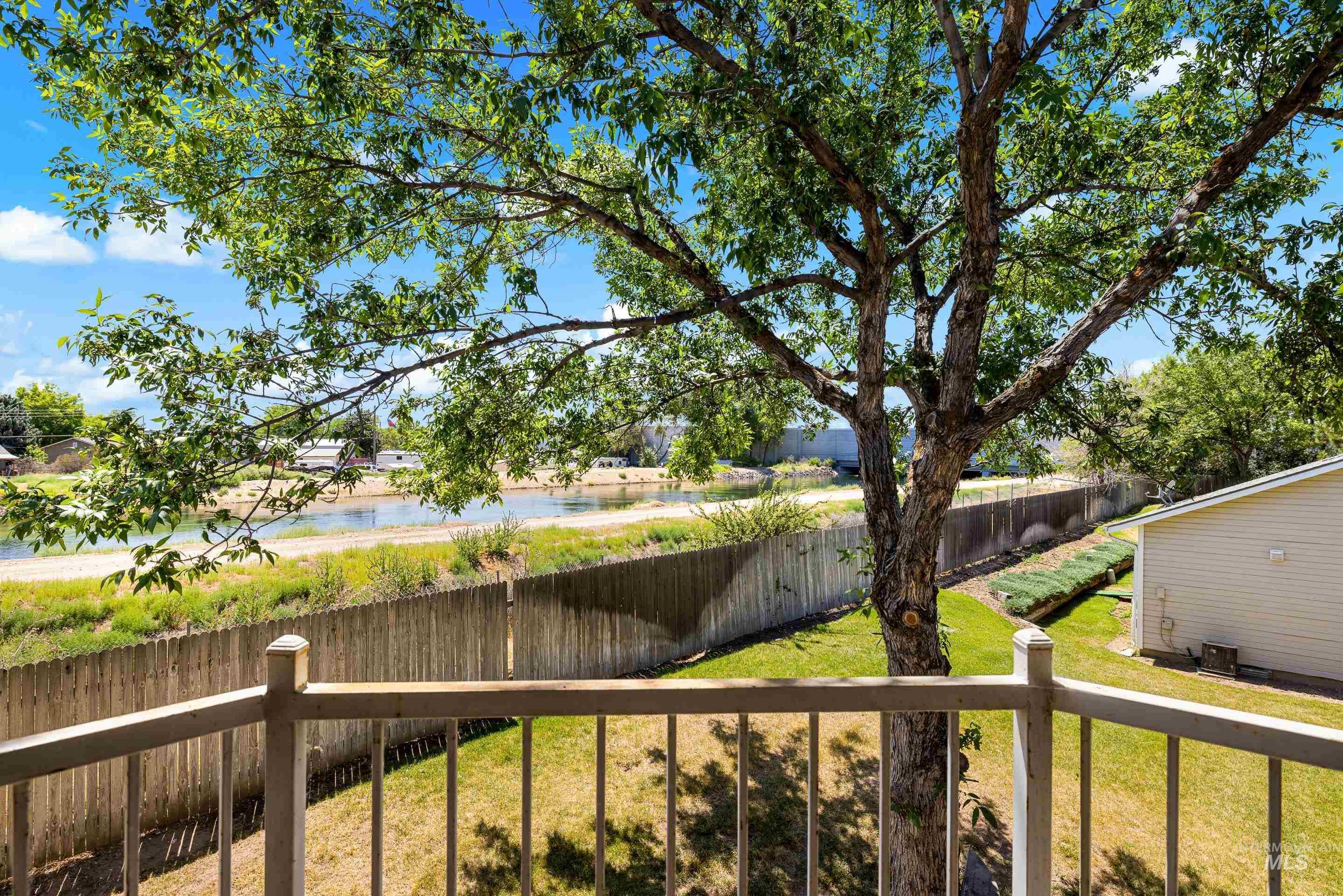 Fenced backyard with a water view.