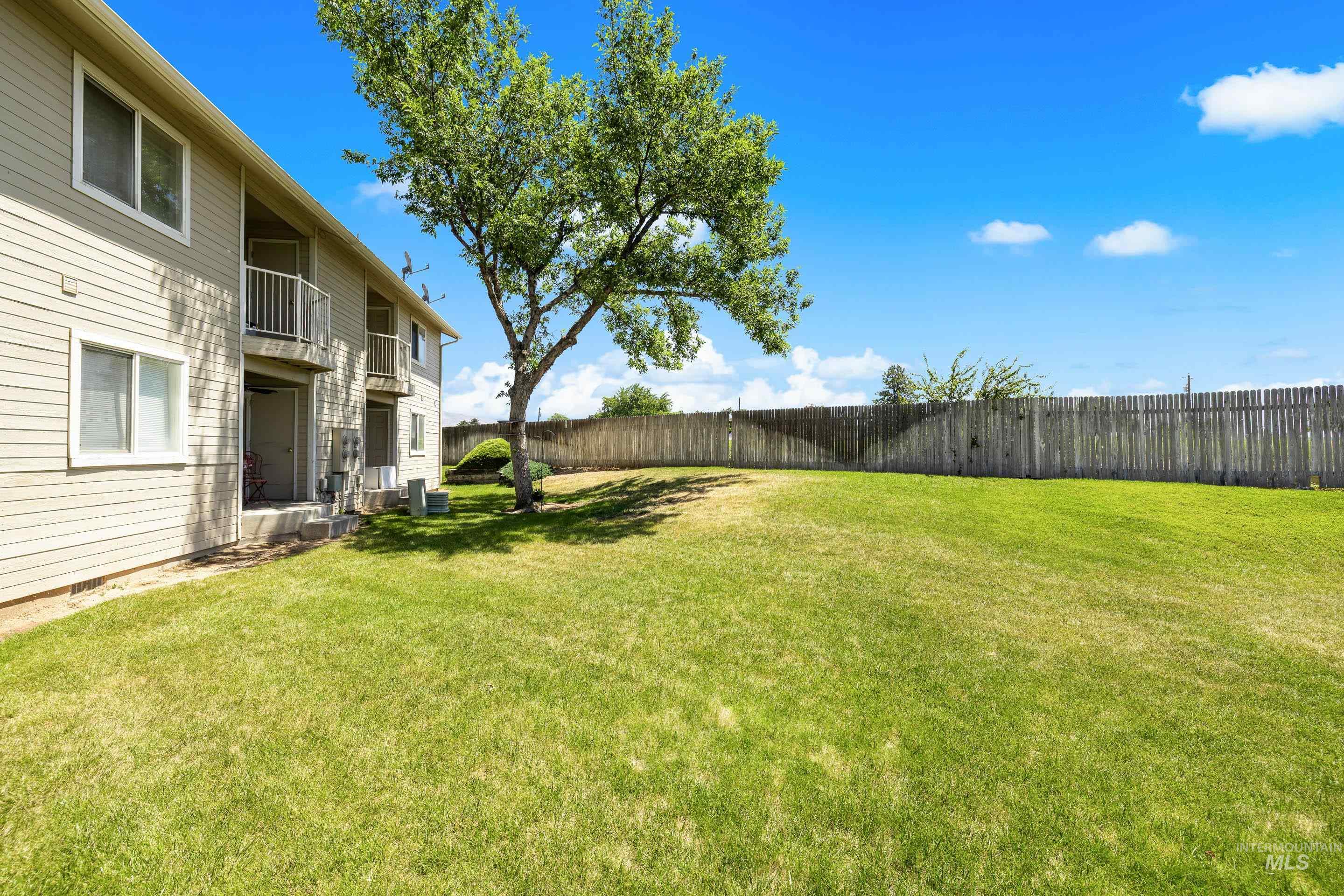 Fenced backyard featuring a balcony