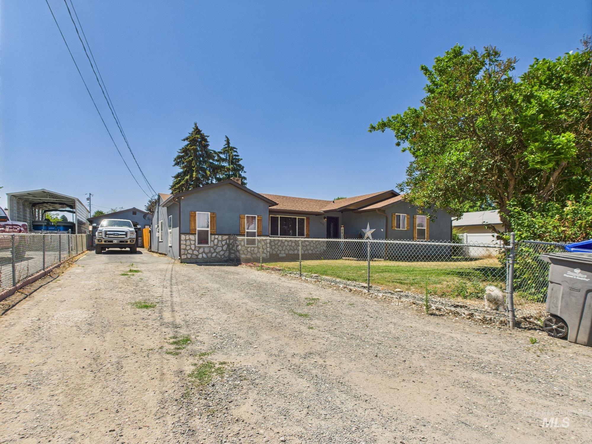 Ranch-style house with stucco siding, driveway, and a detached carport