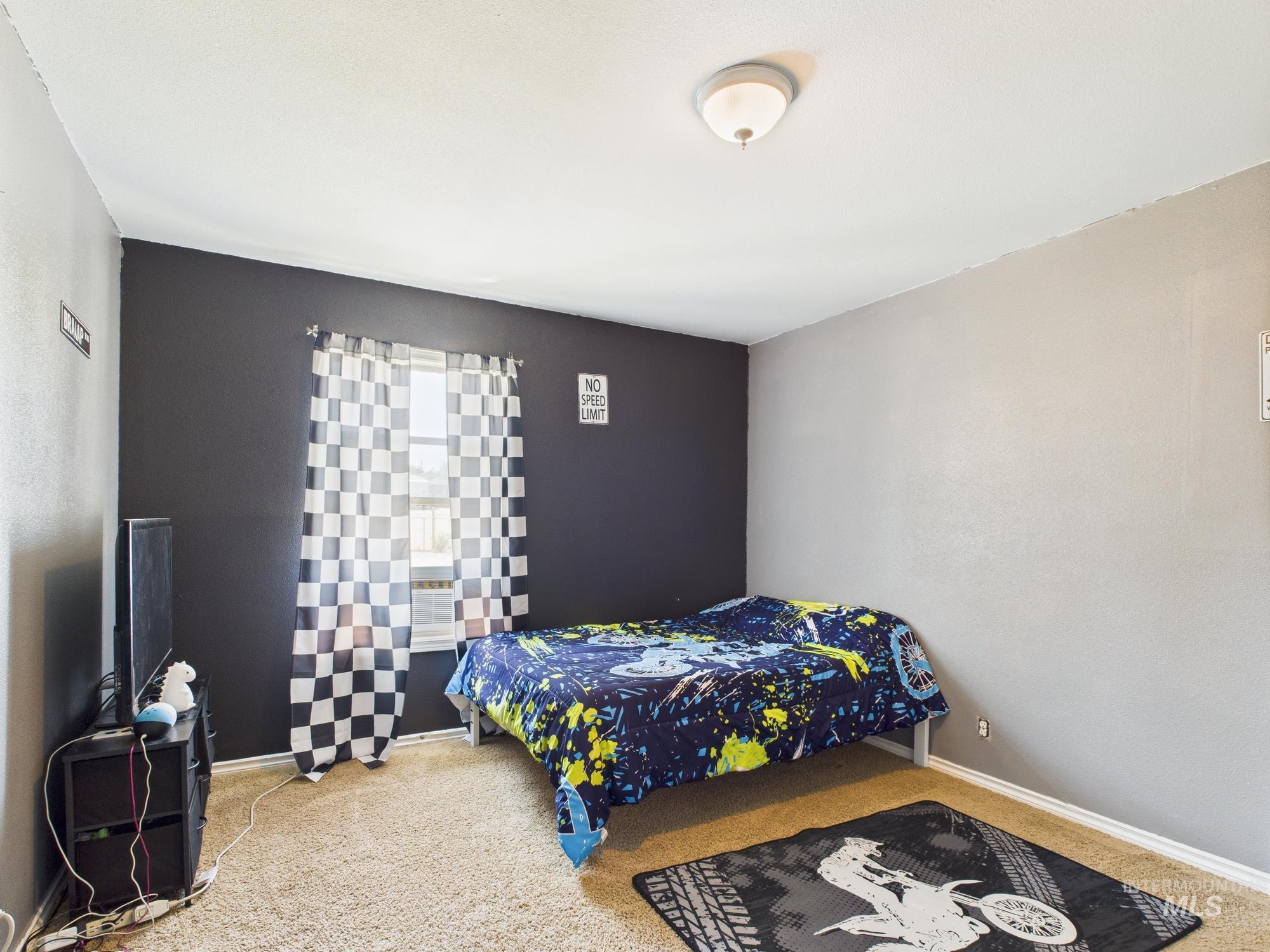 Bedroom featuring carpet and baseboards