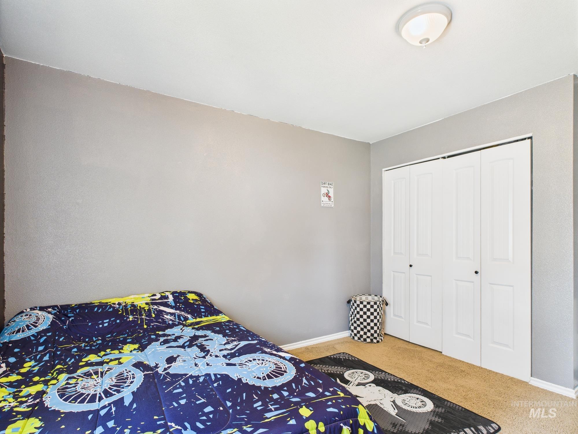 Carpeted bedroom featuring baseboards and a closet