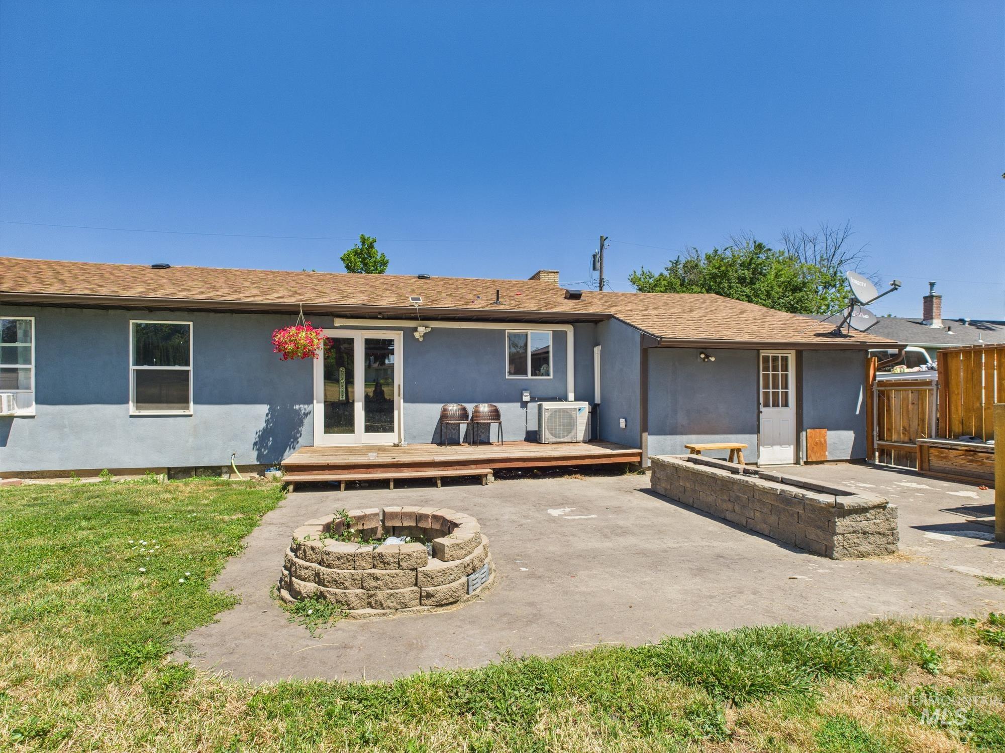 Rear view of house featuring a fire pit, a wooden deck, a patio, and stucco siding