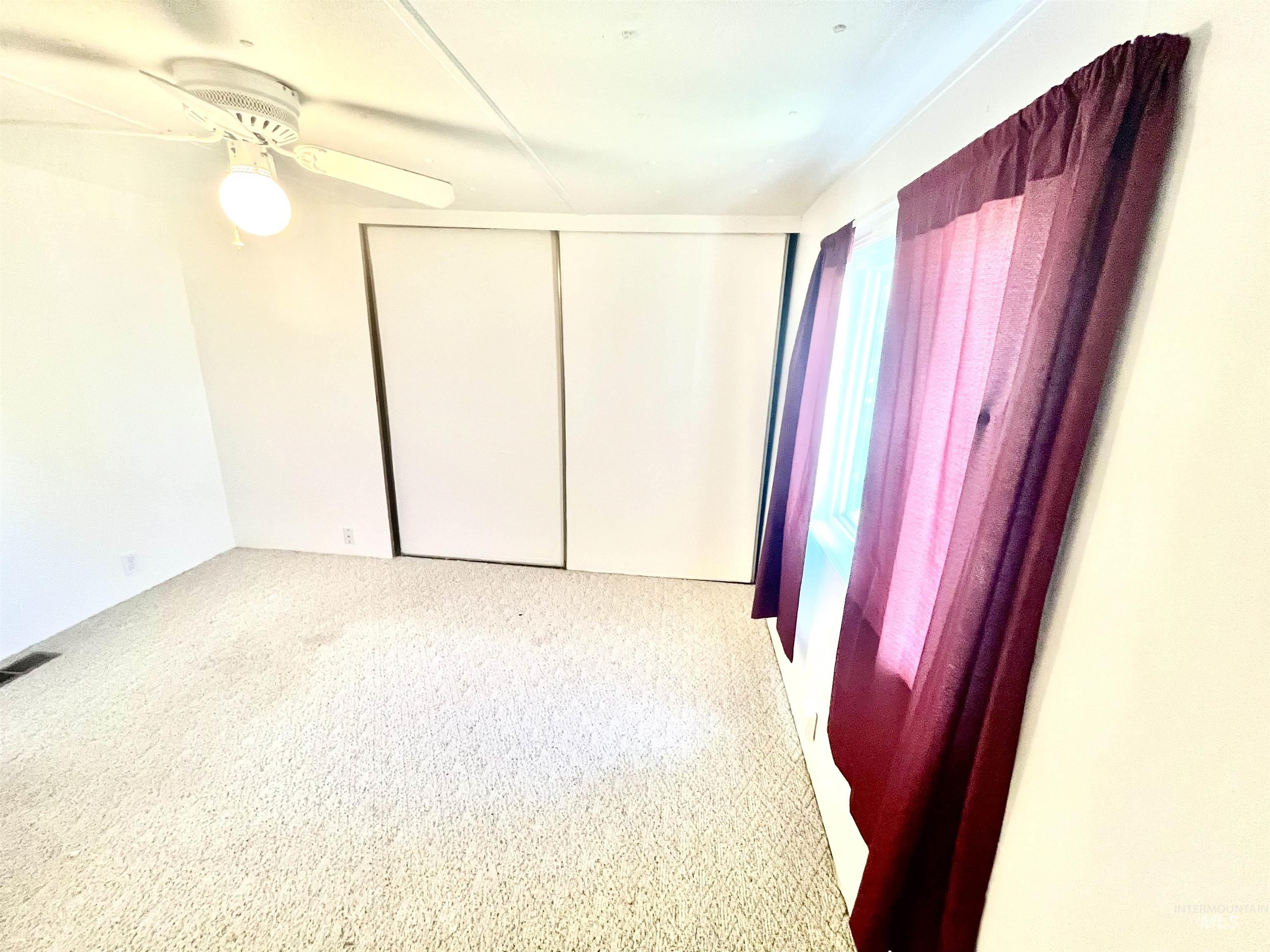 Unfurnished bedroom with carpet flooring, a closet, and ceiling fan
