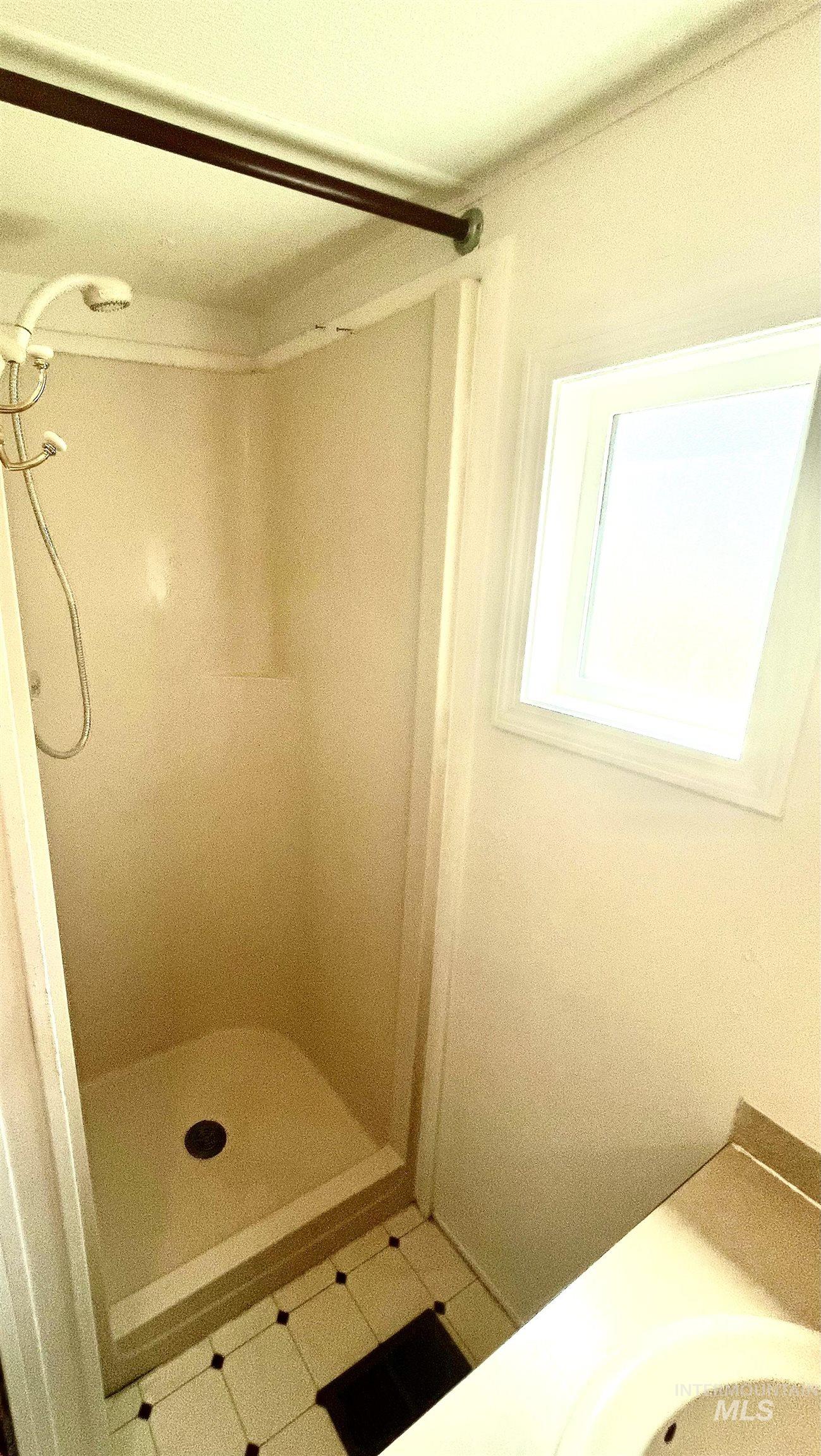 Full bathroom featuring a stall shower, vanity, and tile patterned flooring