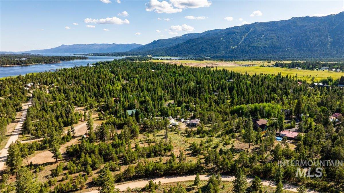 View of mountain backdrop featuring a nearby body of water and a heavily wooded area
