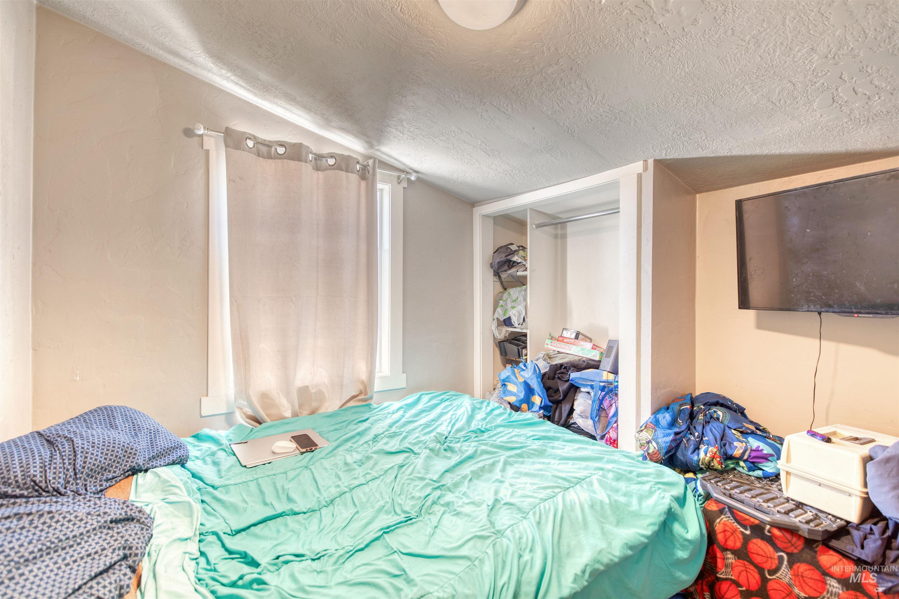 Bedroom featuring a textured ceiling and a closet