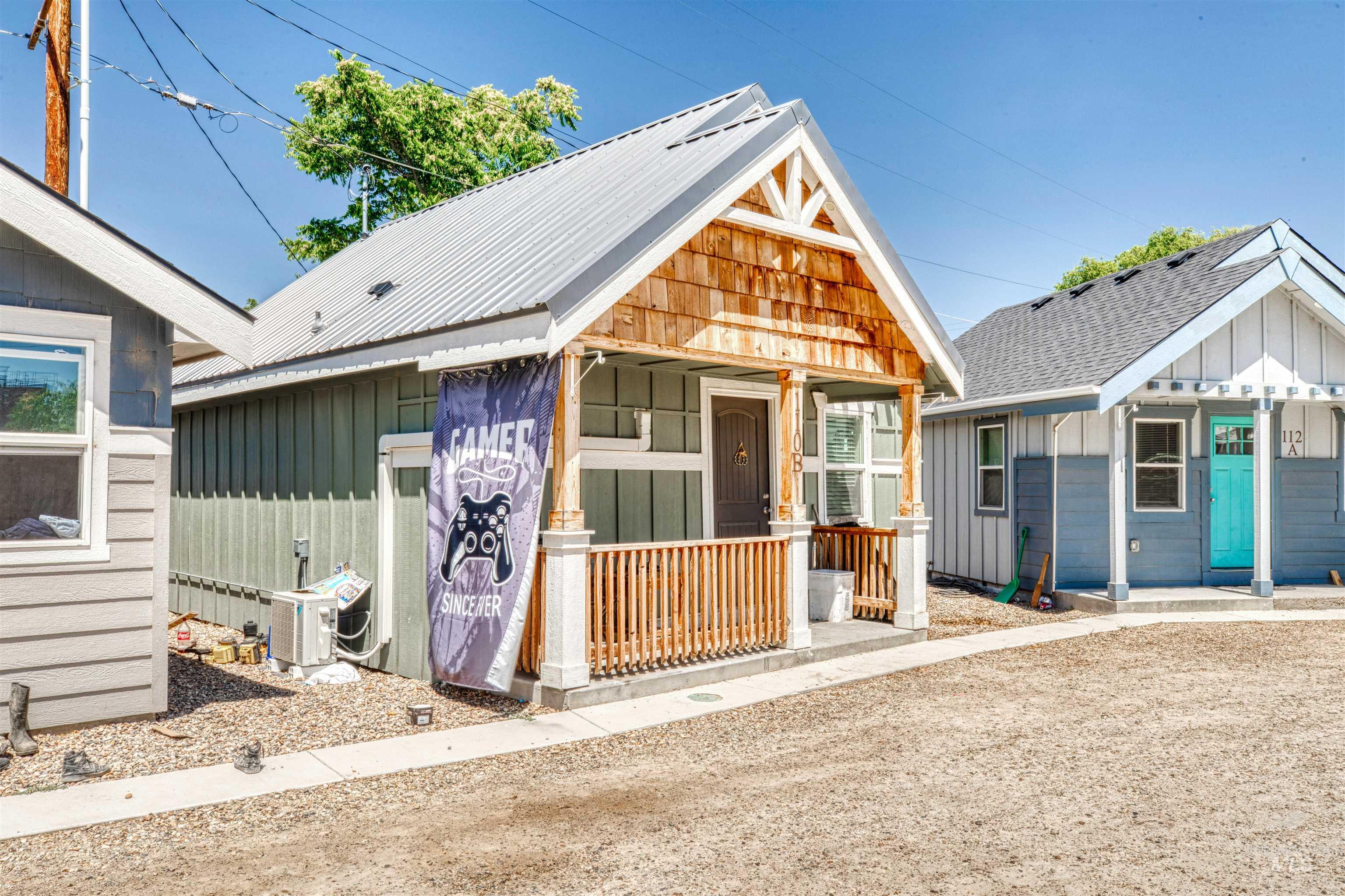 View of front of home with board and batten siding, covered porch, and a metal roof