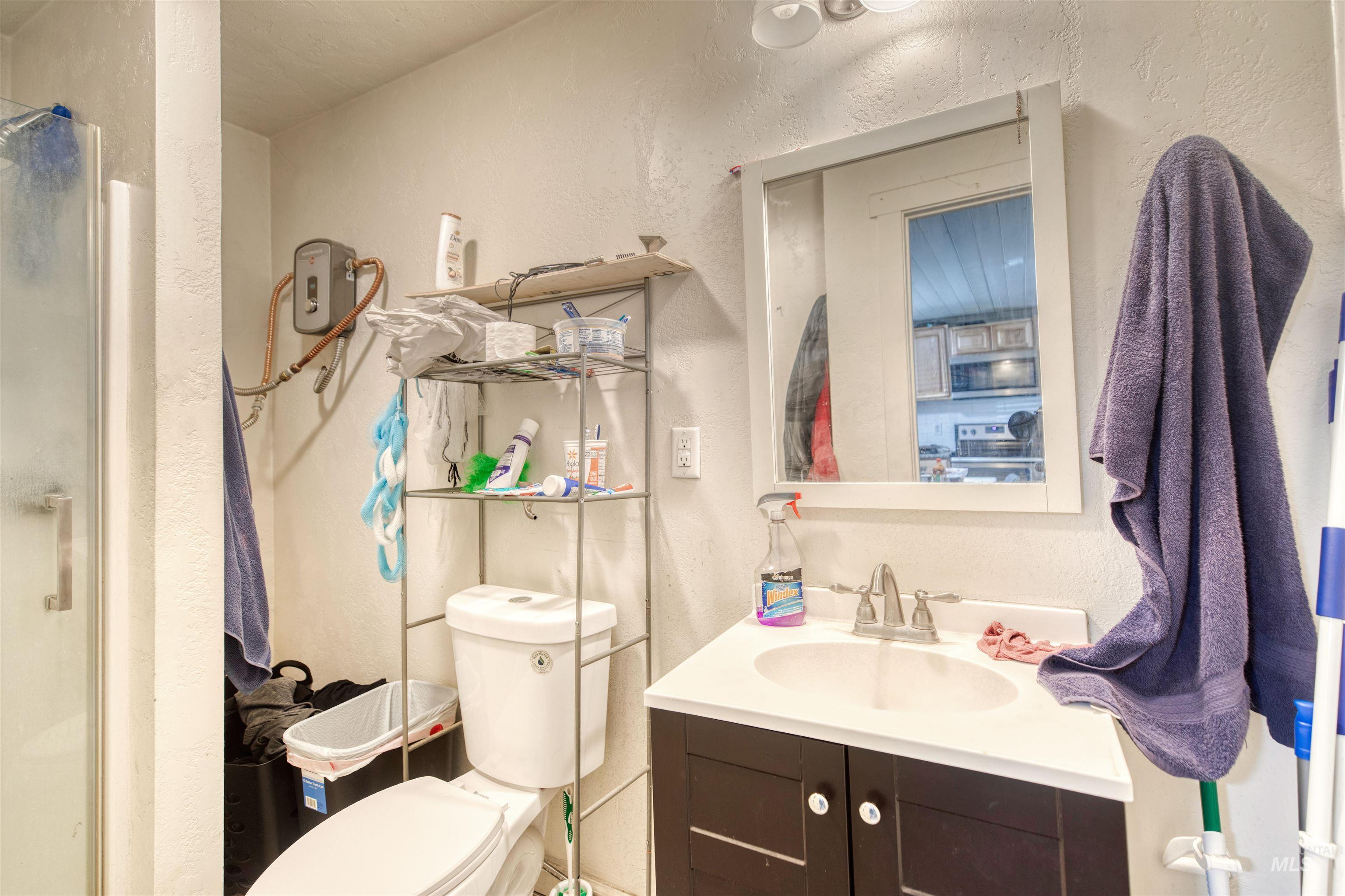 Full bathroom with vanity, a shower stall, and a textured wall
