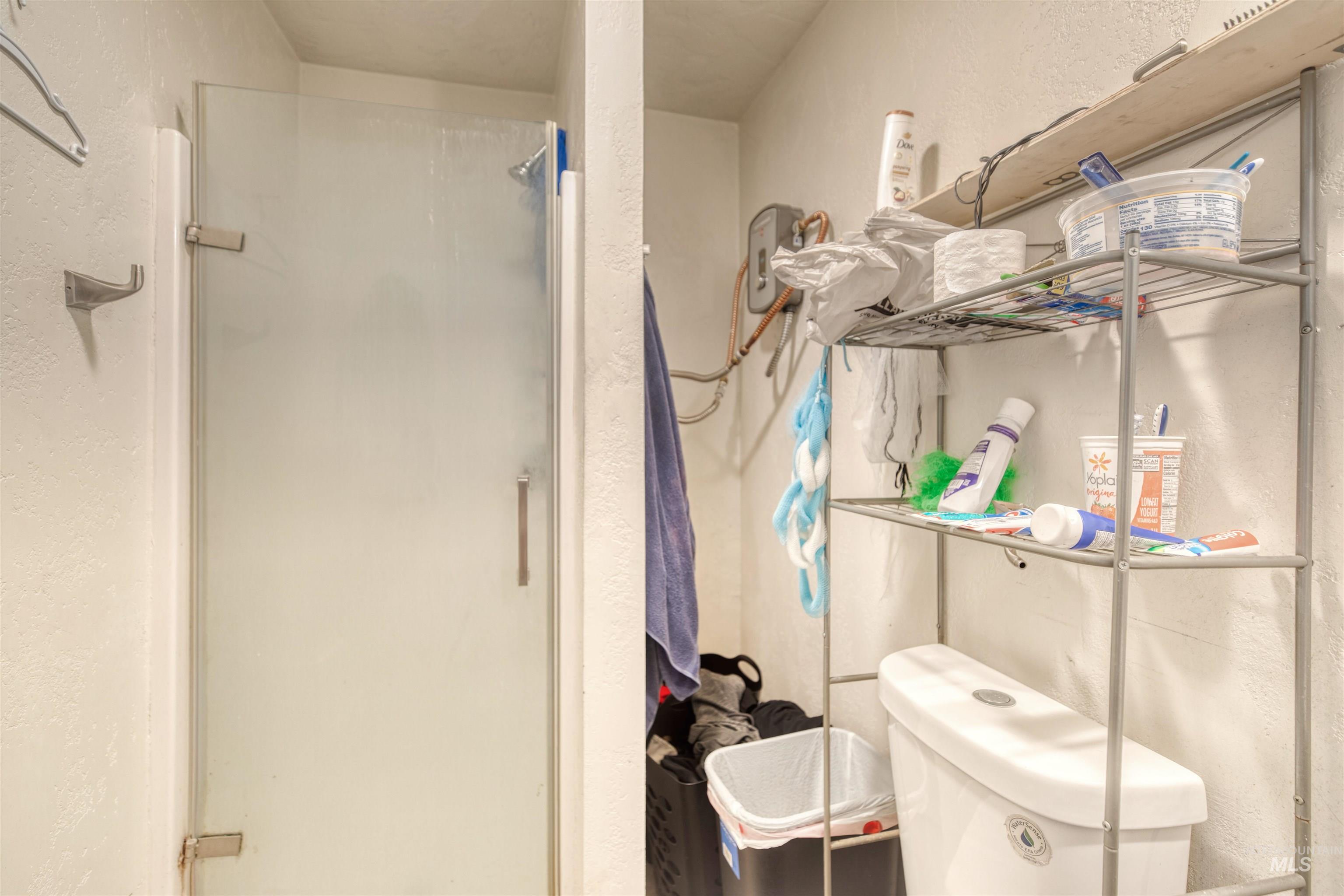 Bathroom featuring a stall shower and a textured wall