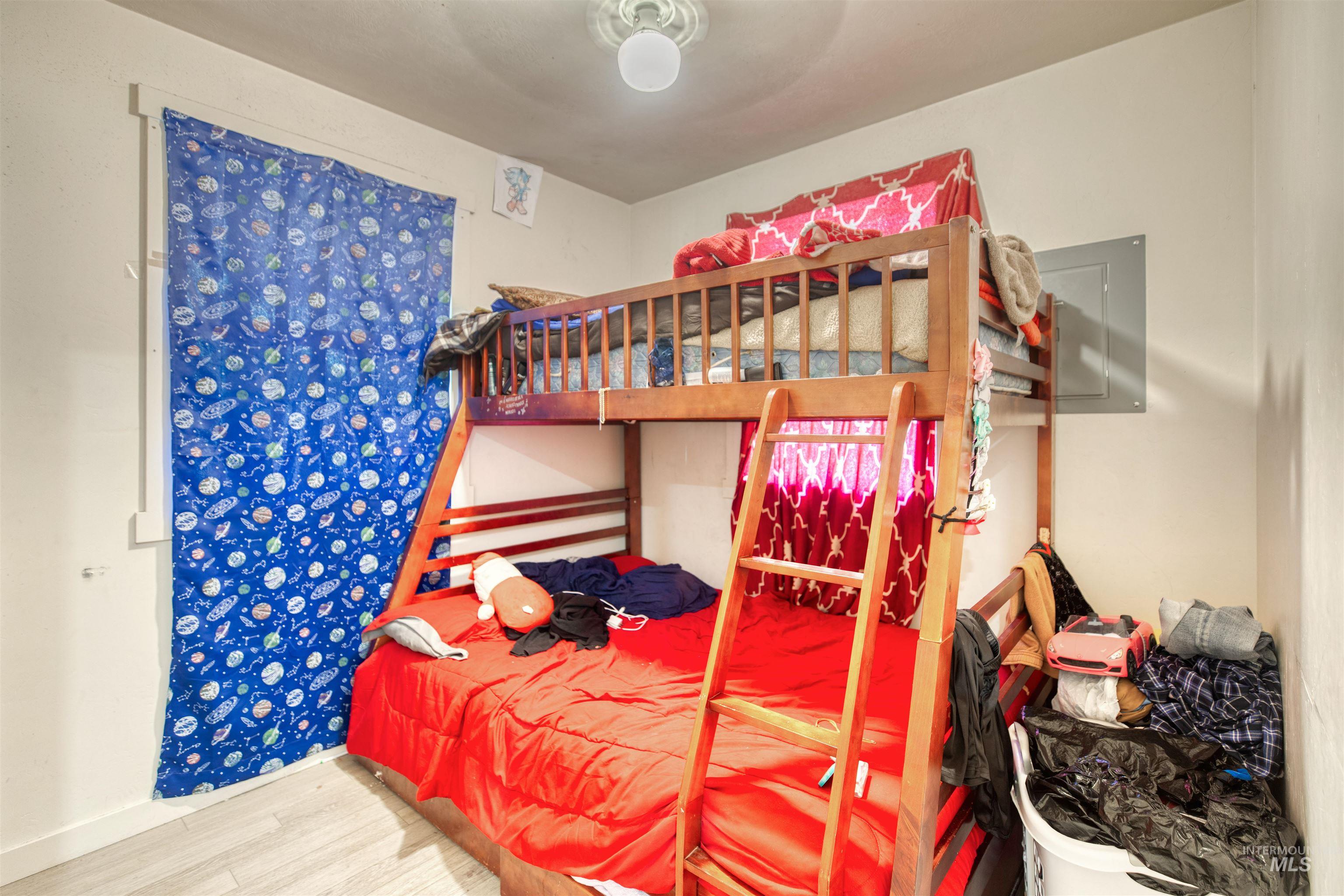 Bedroom featuring wood finished floors and baseboards