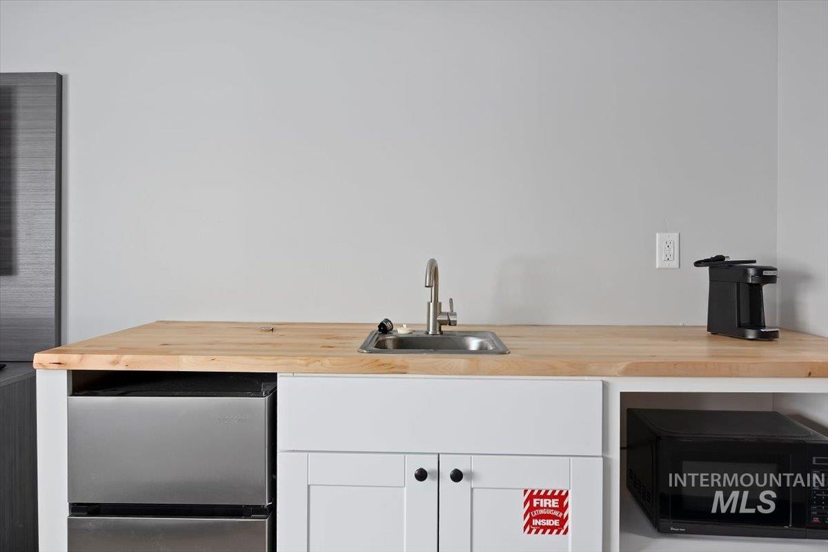 Bar featuring fridge and black microwave