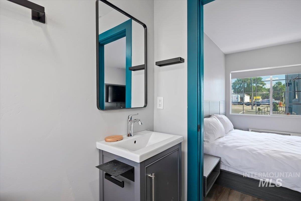 Bathroom featuring vanity, connected bathroom, and wood finished floors