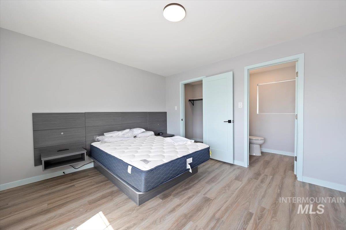 Bedroom with light wood-type flooring and a spacious closet