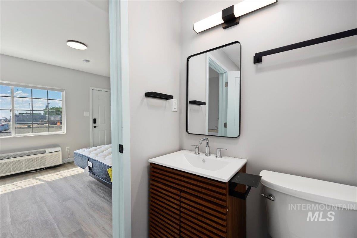 Bathroom with vanity, wood finished floors, and radiator