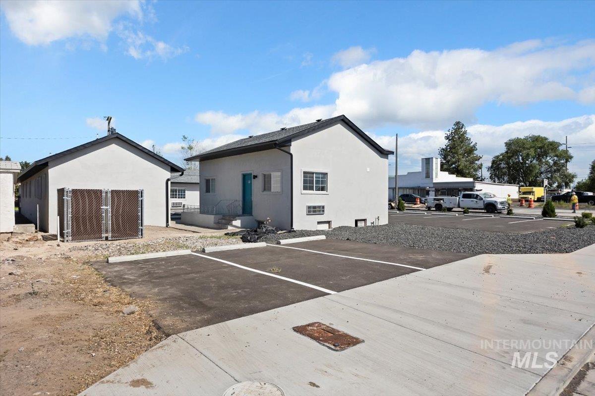 Rear view of property featuring uncovered parking and stucco siding