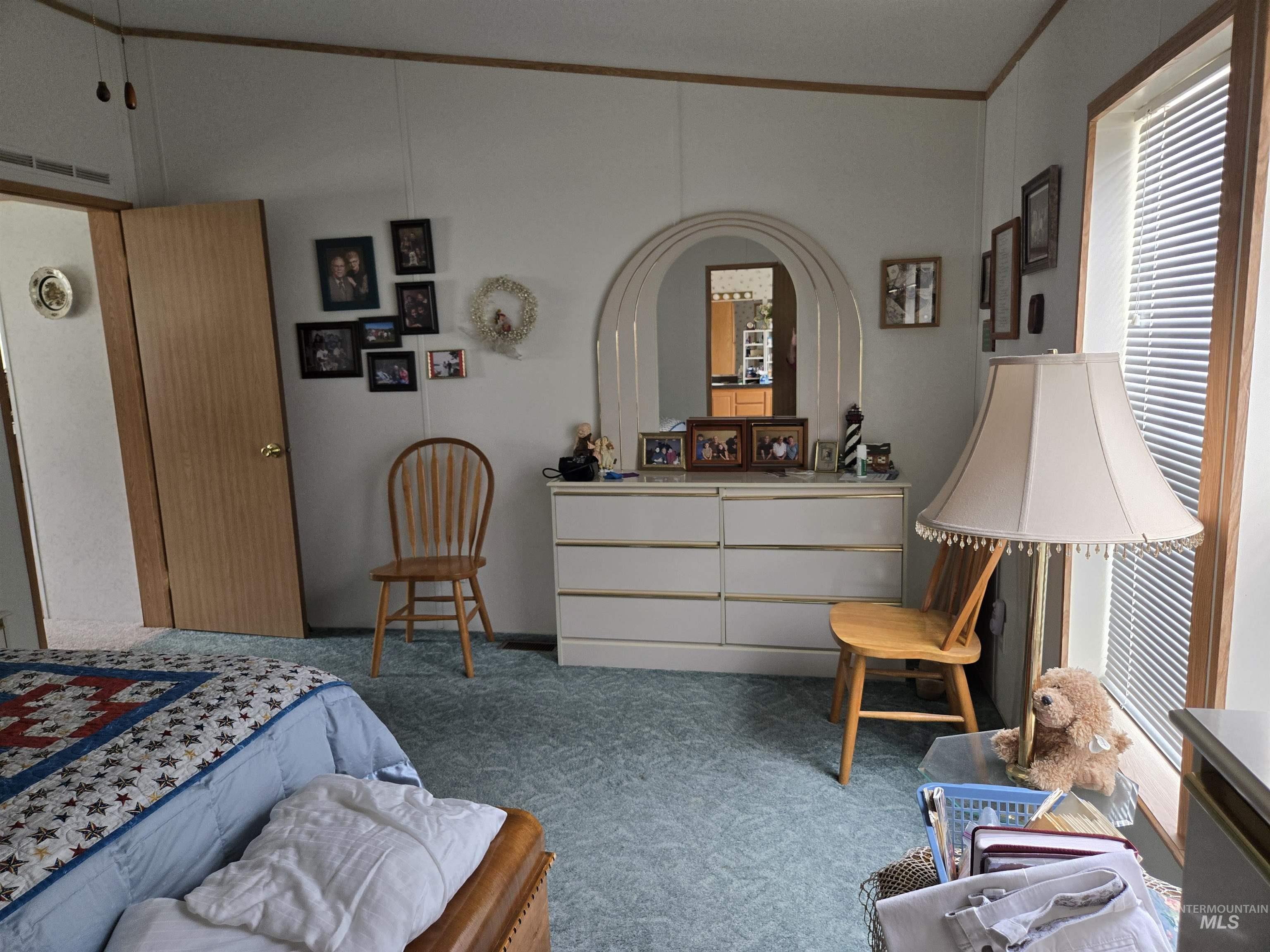 Bedroom with carpet, ornamental molding, and multiple windows