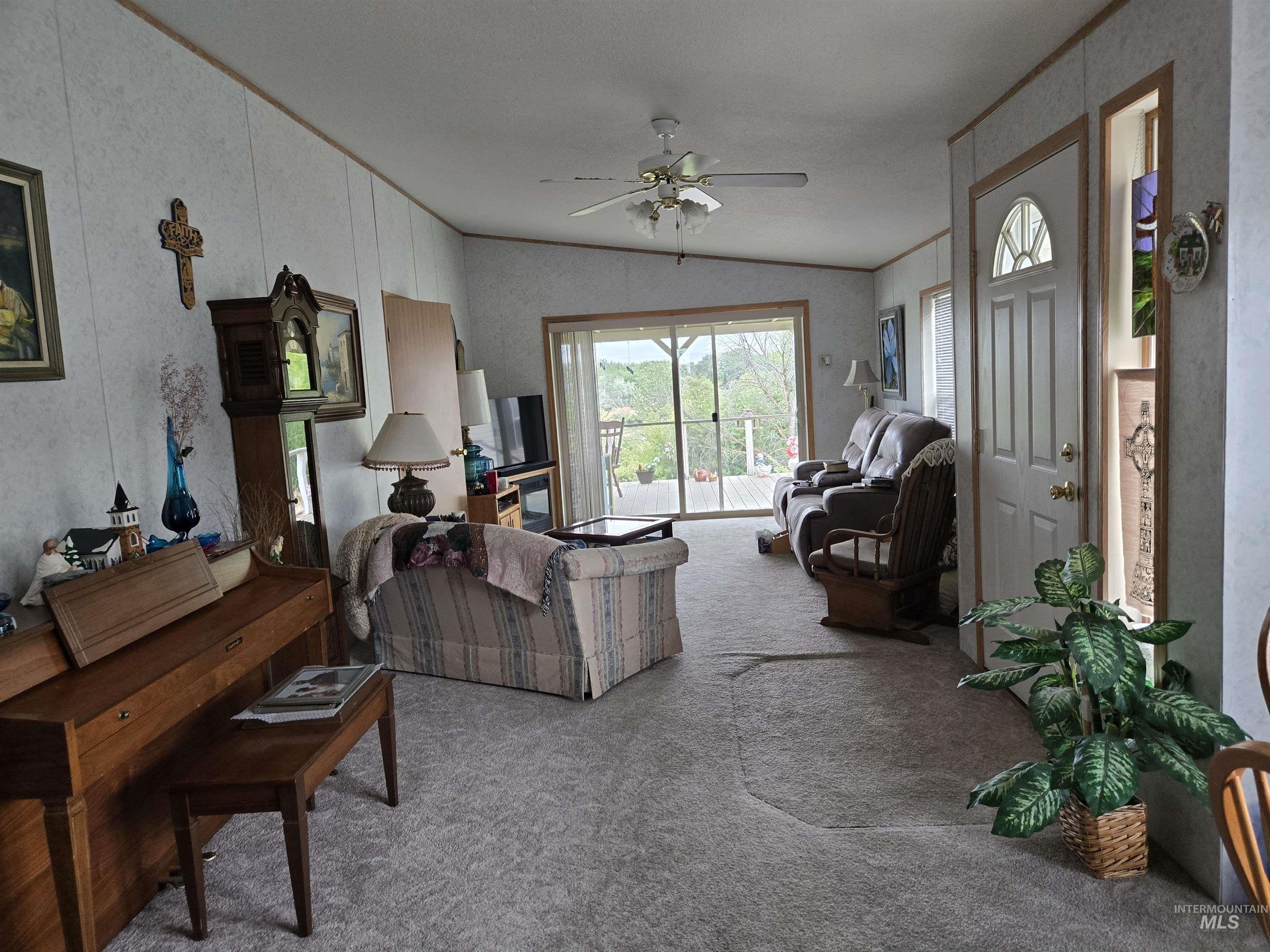 Carpeted living area featuring vaulted ceiling and a ceiling fan