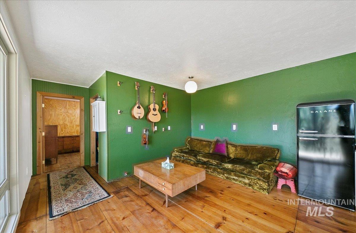 Living area featuring wood-type flooring and a textured ceiling