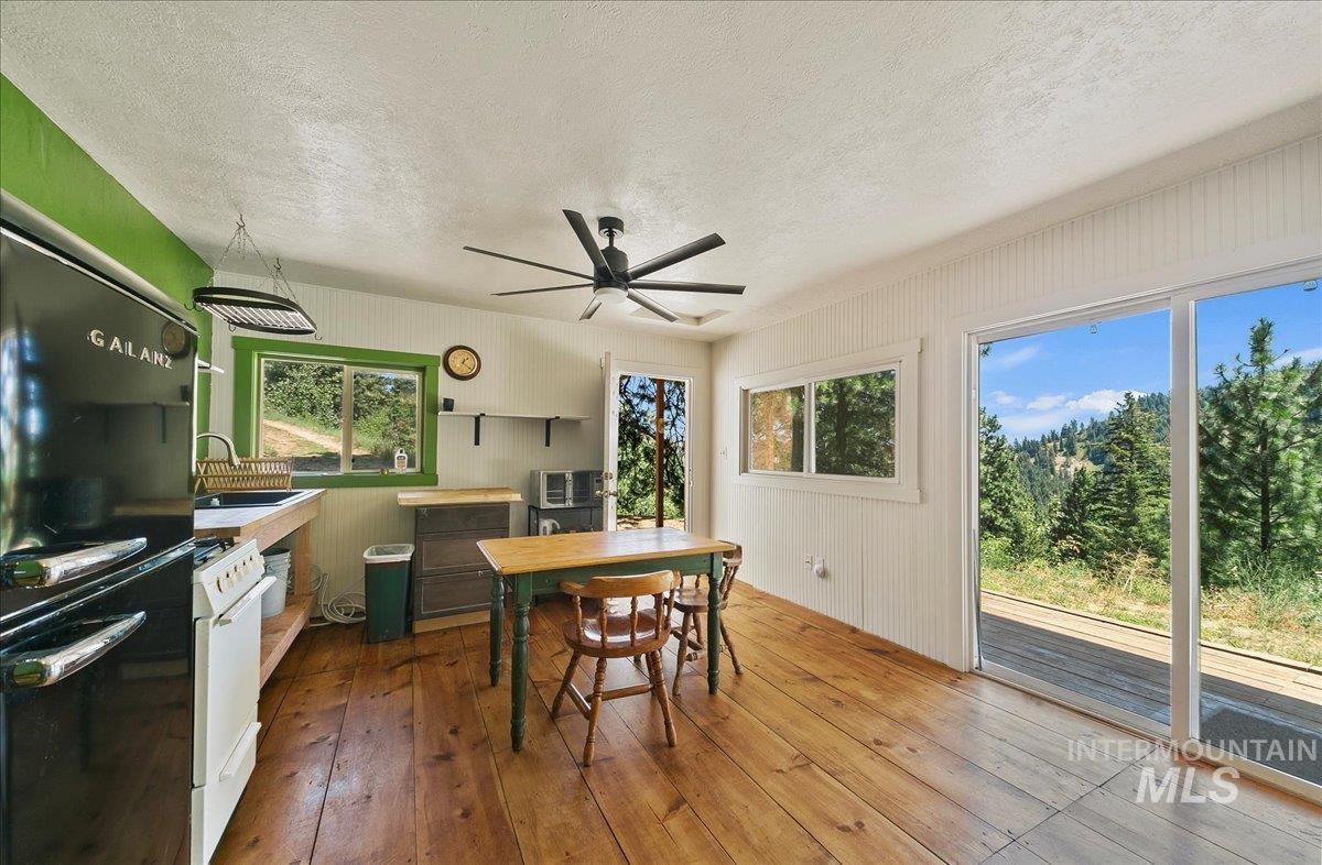 Dining area featuring hardwood / wood-style flooring, a textured ceiling, and a ceiling fan