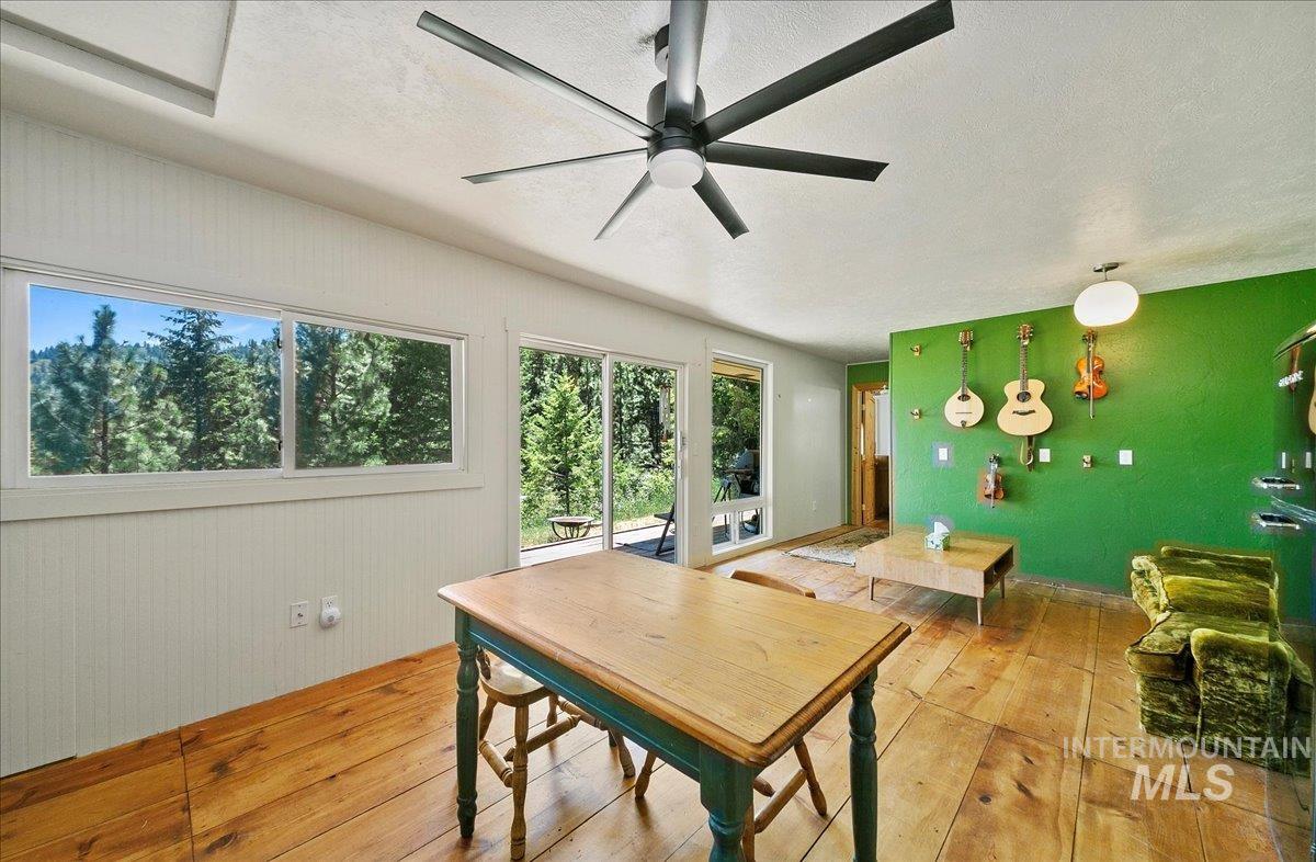 Dining space featuring hardwood / wood-style flooring, ceiling fan, and a textured ceiling
