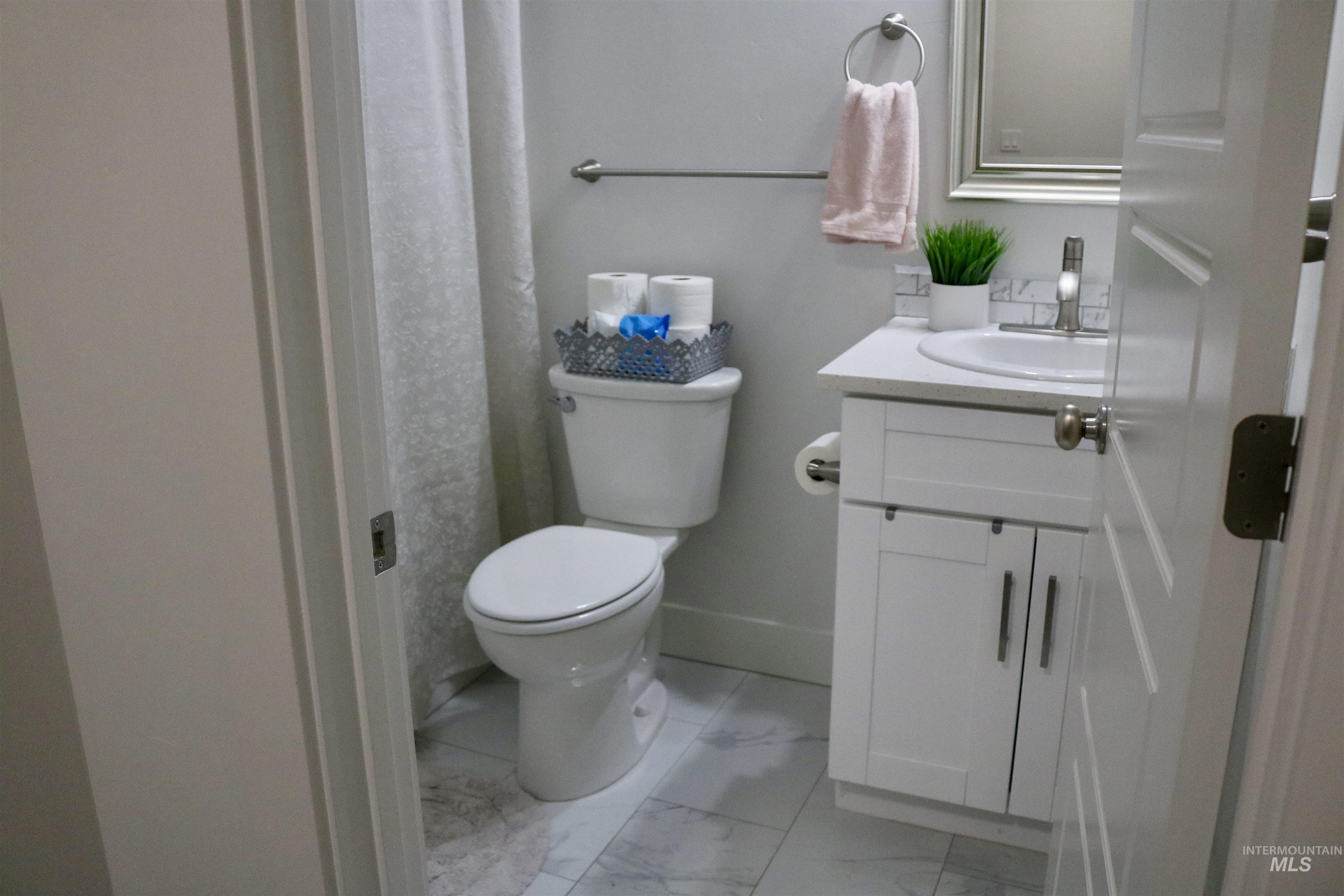 Full bathroom with marble look tiles and vanity