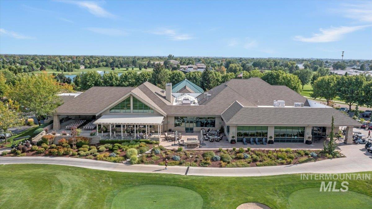 View from above of property with a golf course and a tree filled landscape