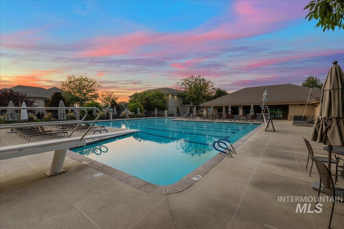 Pool at dusk with a patio and a community pool