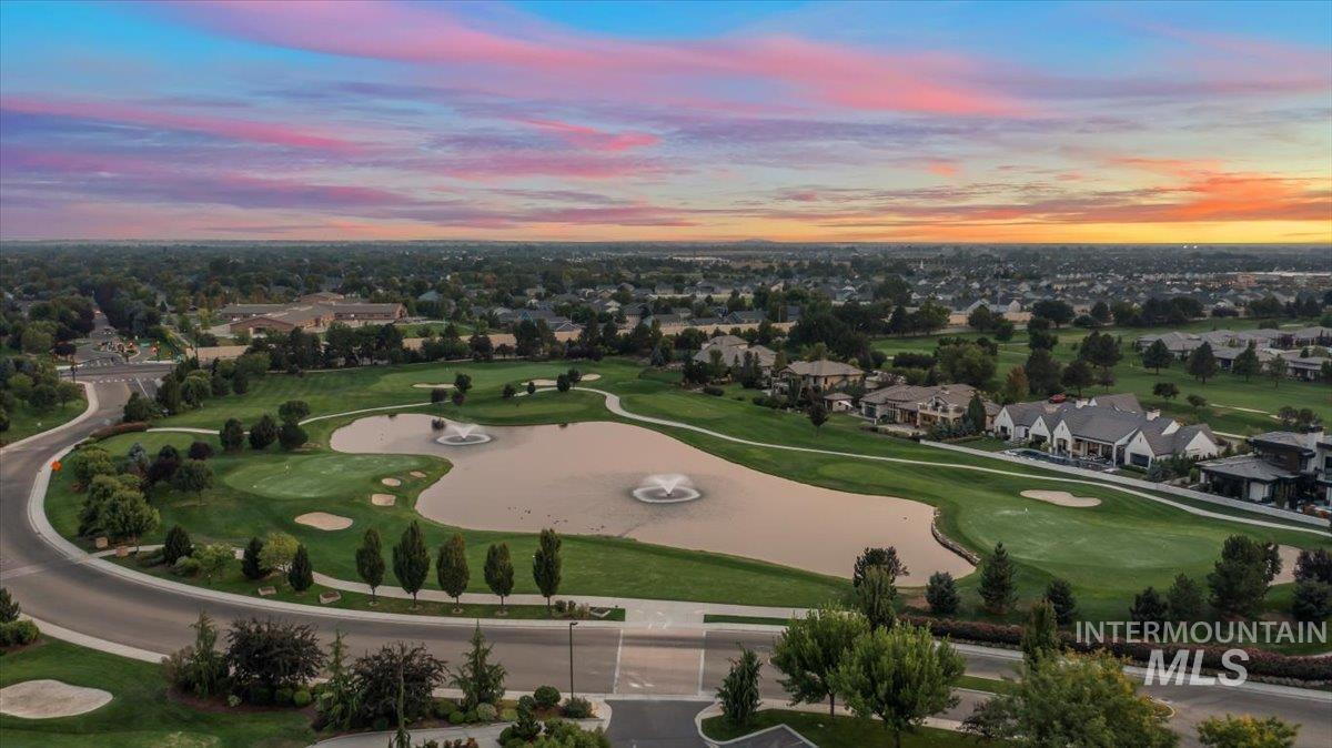 Aerial overview of property's location featuring nearby suburban area, a nearby body of water, and a golf course