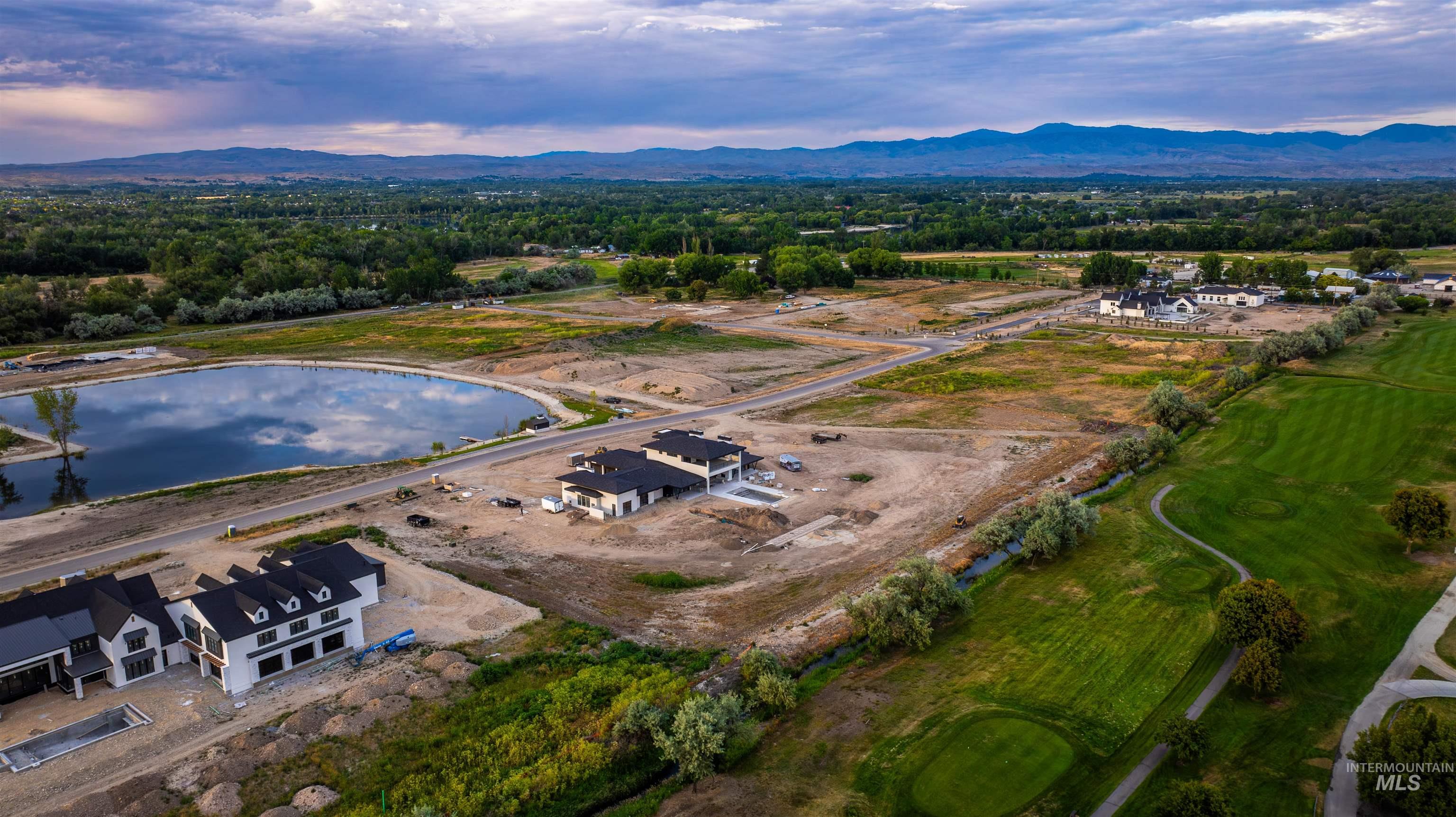 Aerial overview of property's location featuring a water and mountain view and a local golf course