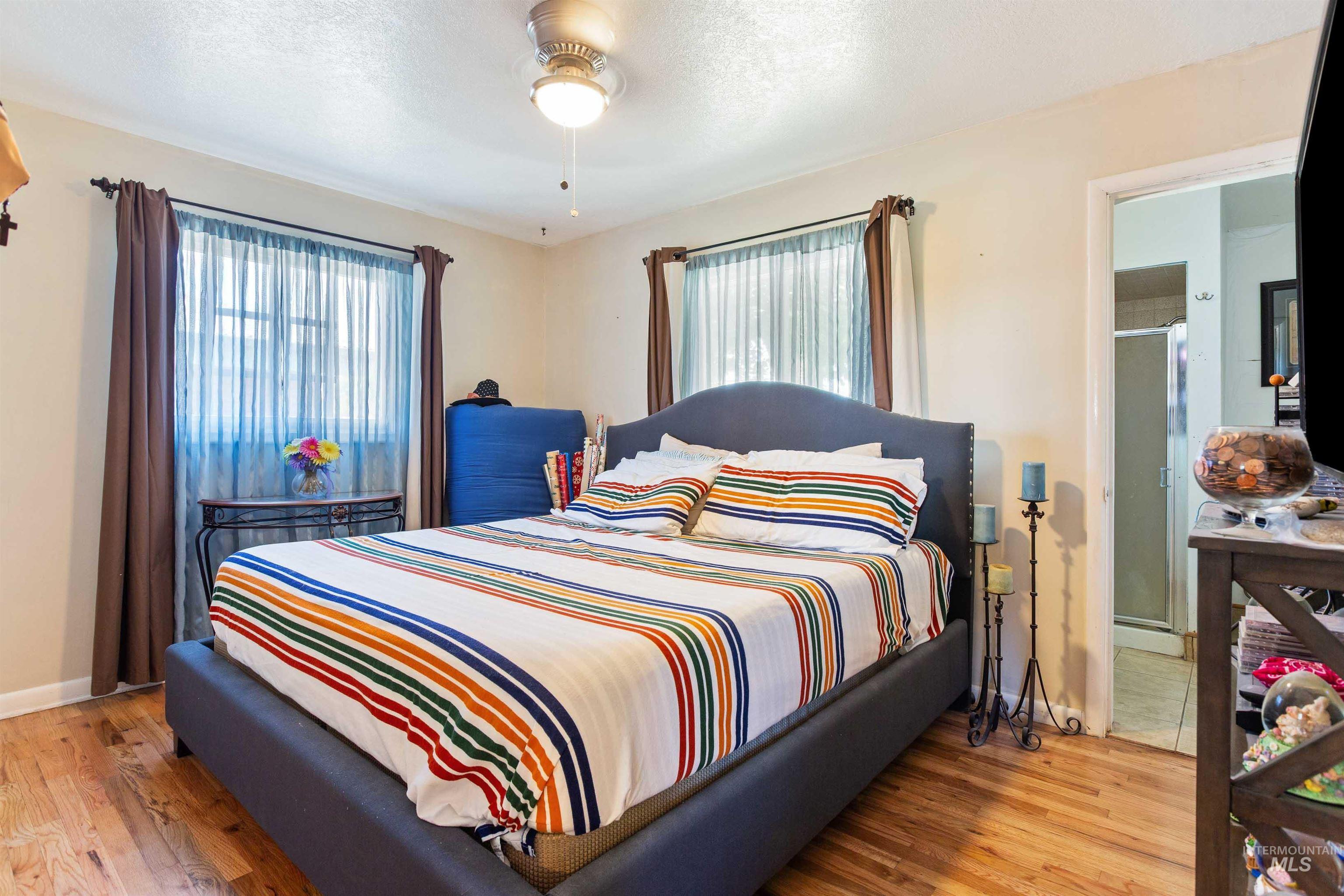Bedroom featuring wood finished floors, a textured ceiling, and ceiling fan