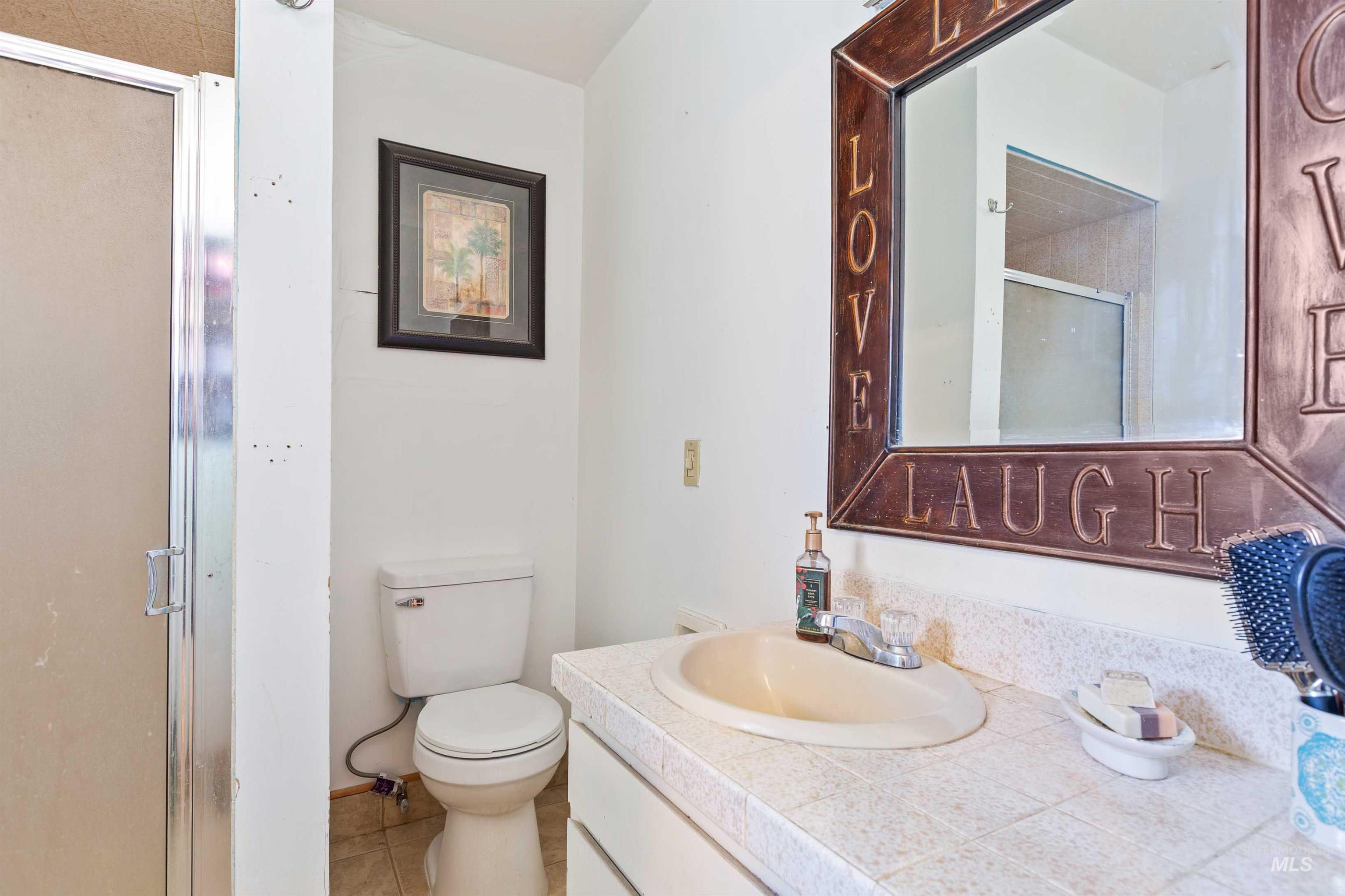 Full bathroom featuring a shower stall, vanity, and tile patterned flooring