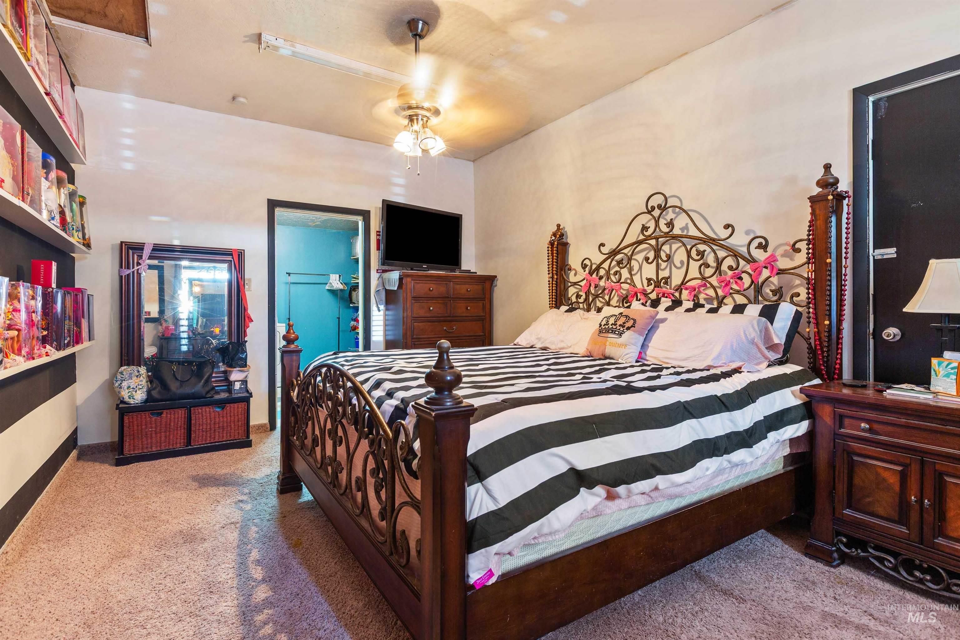Carpeted bedroom with a ceiling fan