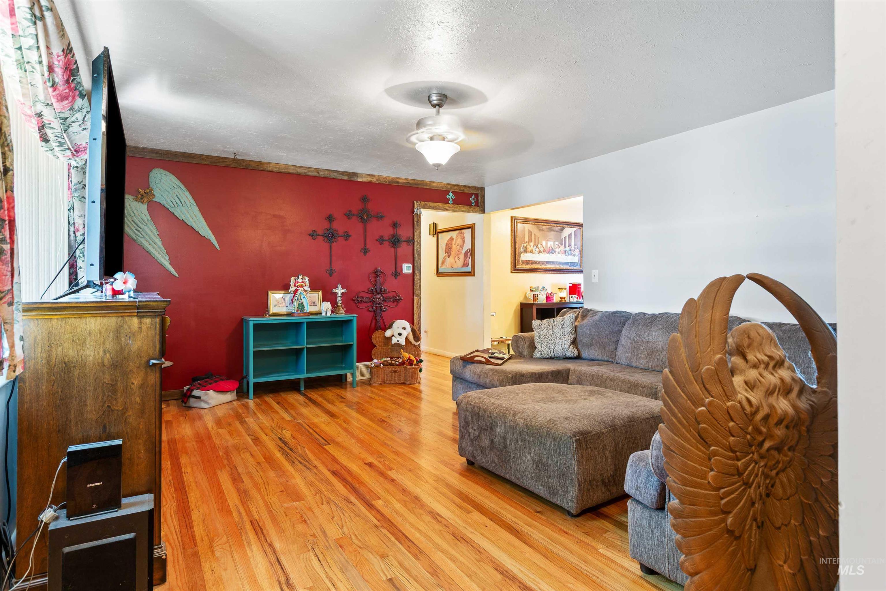 Living room featuring ceiling fan and light wood-style flooring