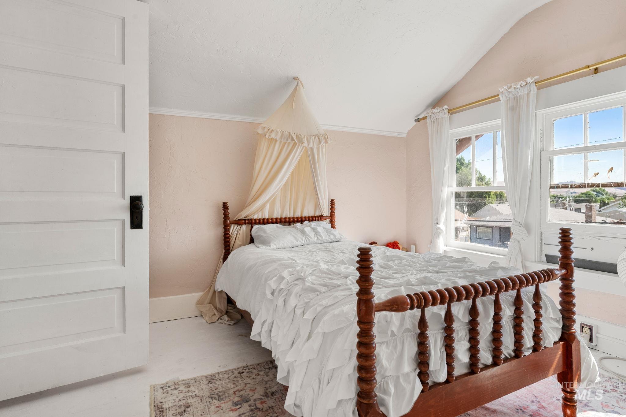 Bedroom with lofted ceiling and baseboards