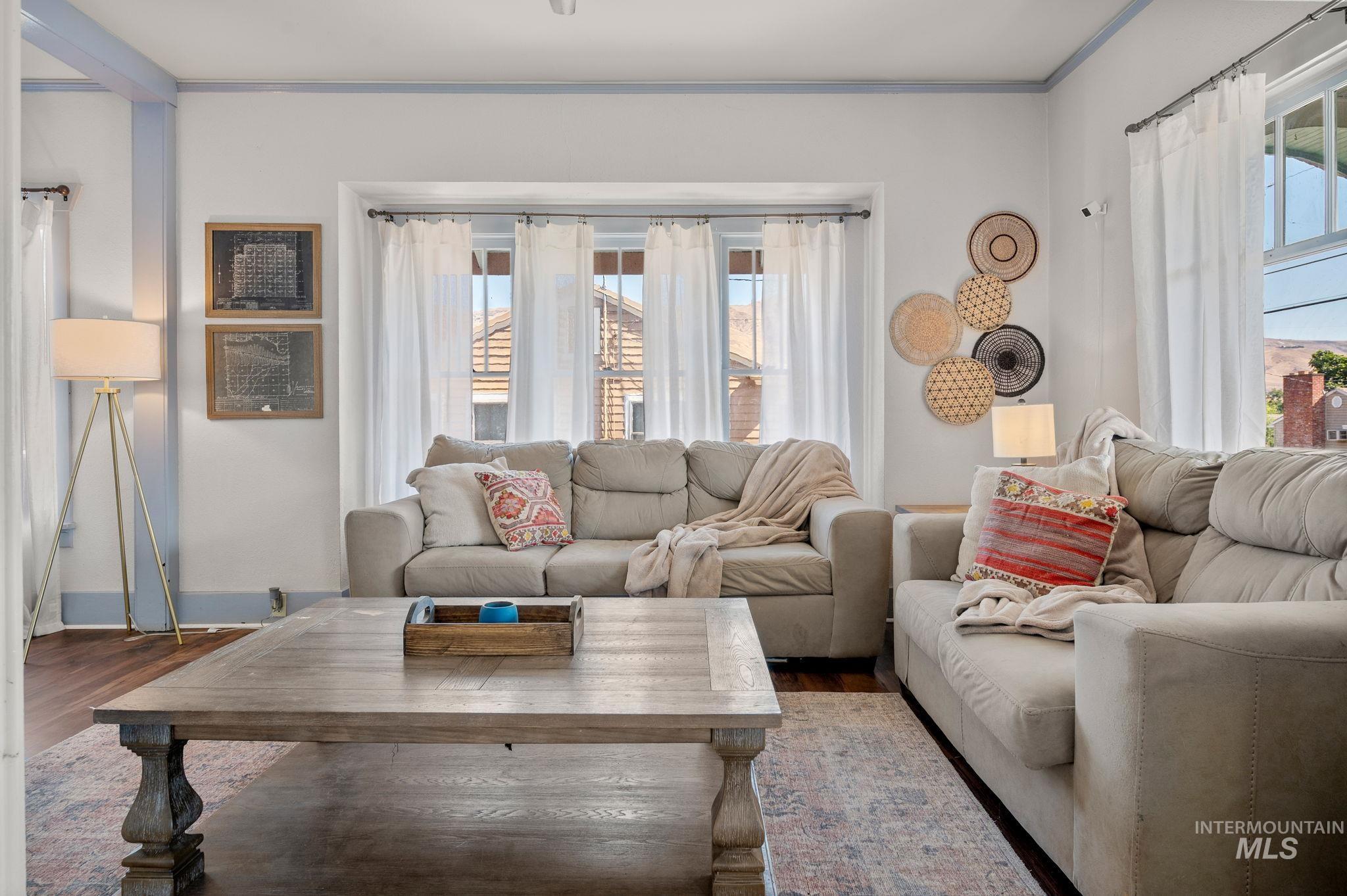 Living area featuring wood finished floors and crown molding