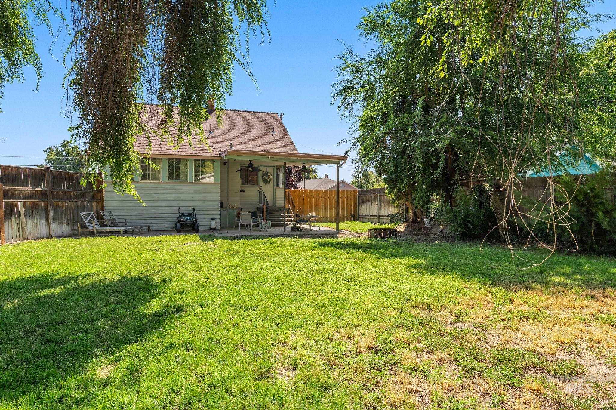 Rear view of house with entry steps, a fenced backyard, and a patio area