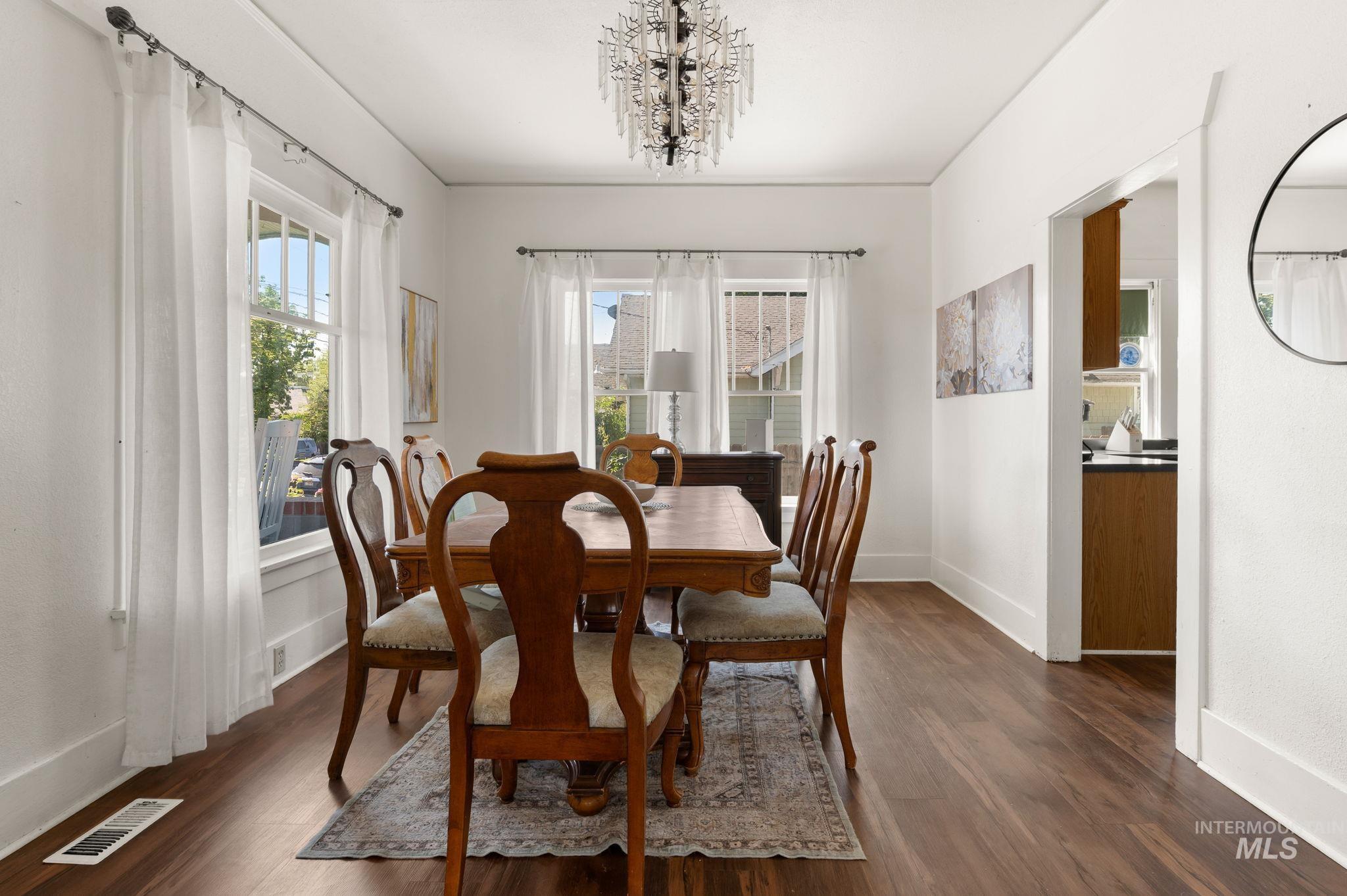Dining space featuring dark wood-type flooring and a chandelier