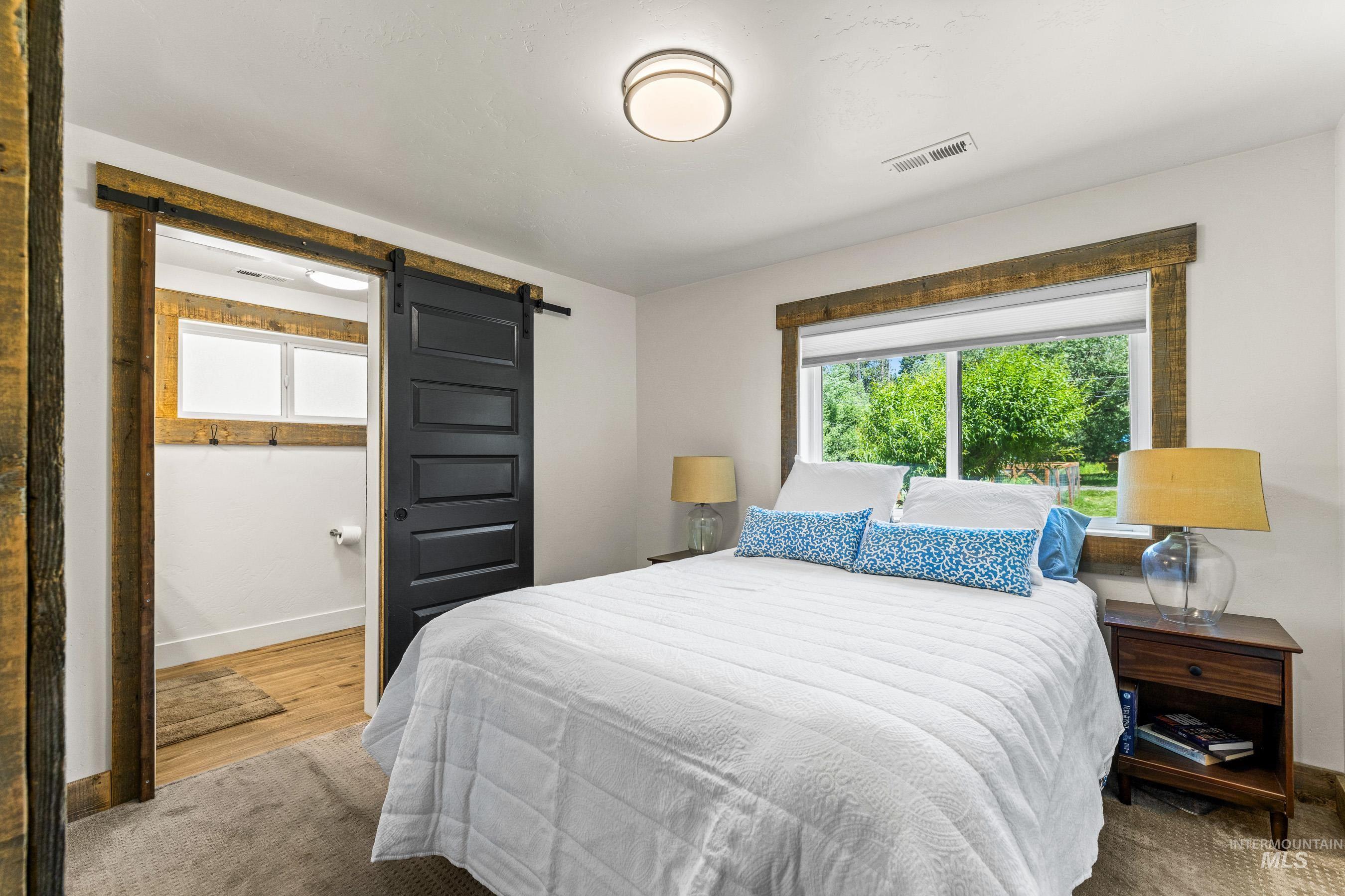 Bedroom with a barn door and wood finished floors